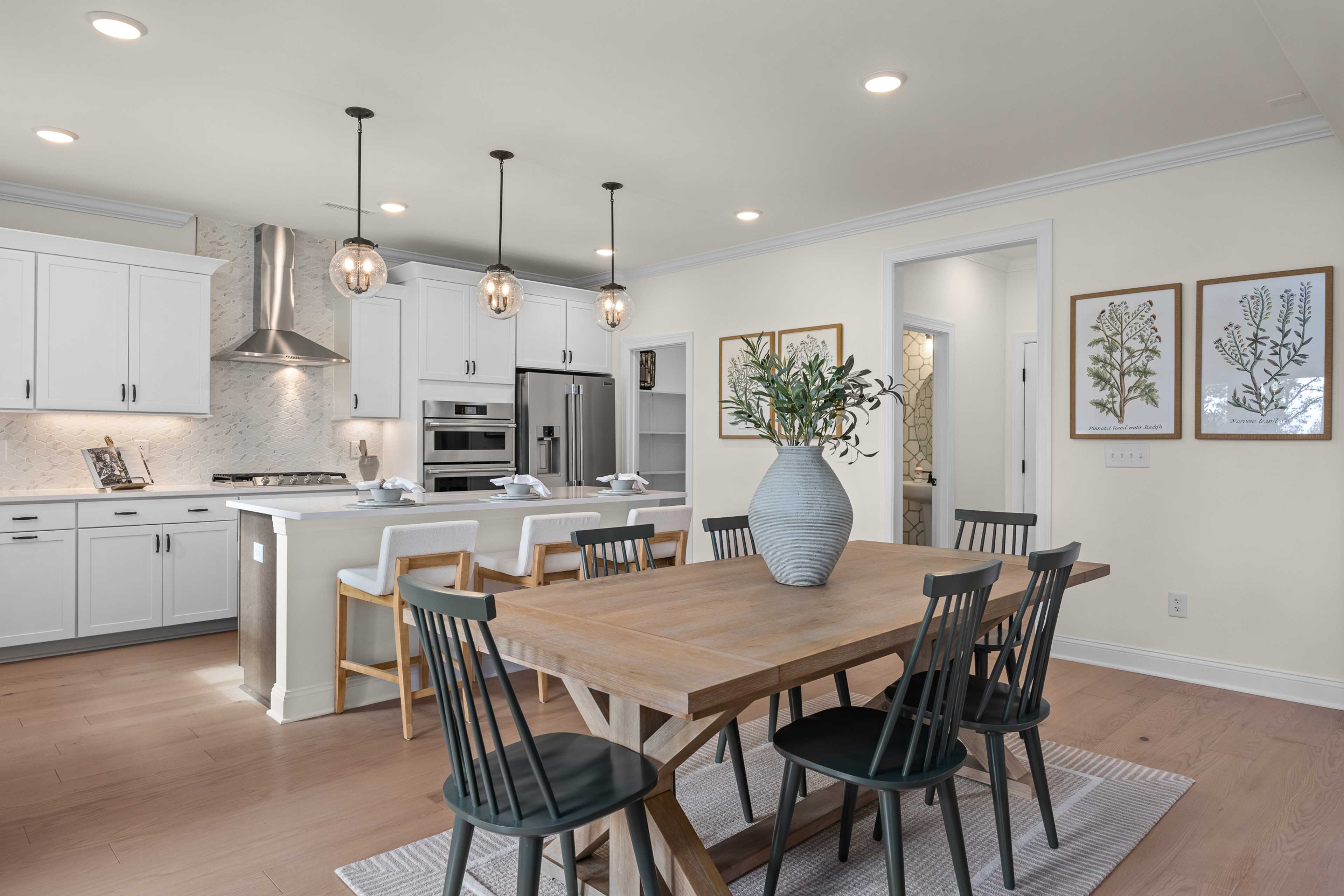 Spacious open-concept kitchen dining area at Laneridge Estates Raleigh NC with white cabinets farmhouse table pendant lights