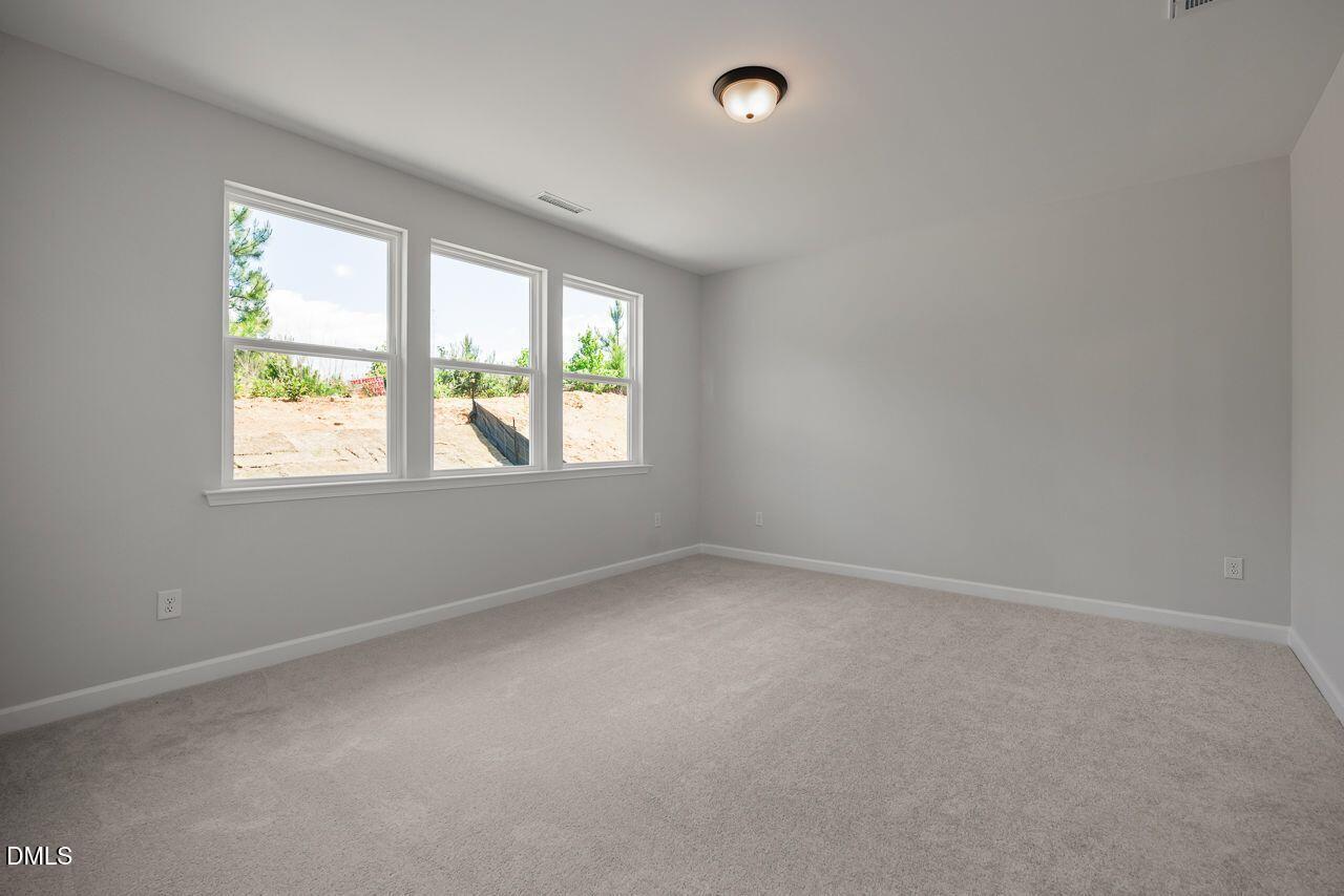 Bright, spacious secondary bedroom with neutral carpet in The Birch II A floor plan by Davidson Homes in Aberdeen, NC.
