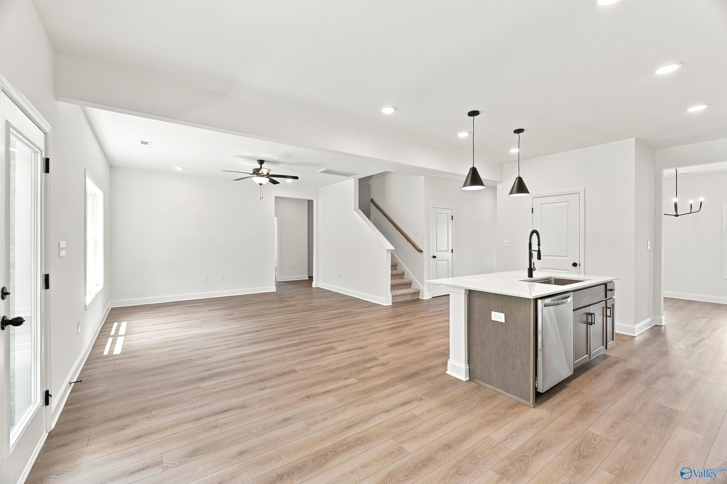 Open-concept kitchen and living area with hardwood floors in The Shelby B floor plan at Jaguar Hills, Huntsville, Alabama.