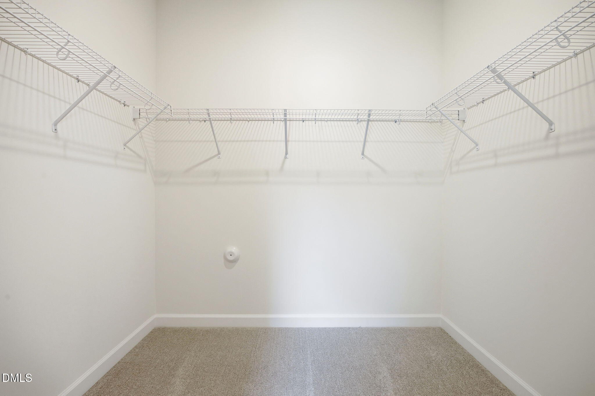 Spacious walk-in closet with white wire shelving in The Ashport M floor plan at Wendell Ridge, Wendell, North Carolina.