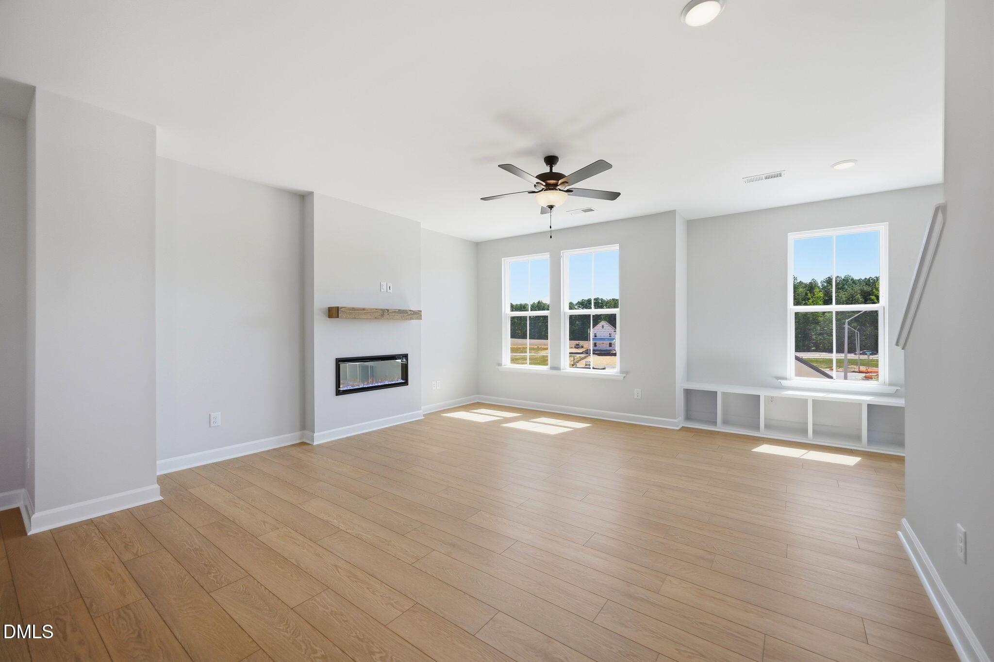Bright, open living room with linear fireplace and built-in storage in The Avery floor plan, Forestville Yard, Knightdale.