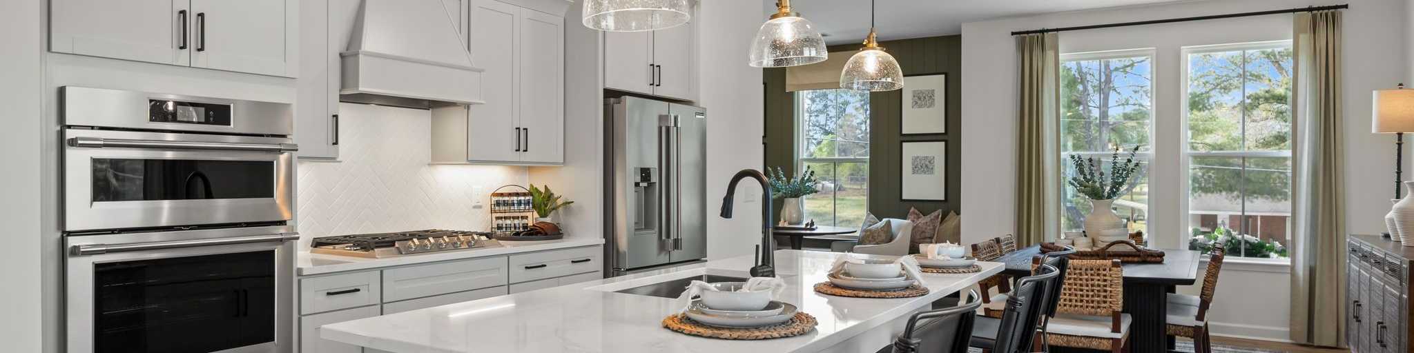 Spacious modern kitchen in Summers Walk Davidson NC with white cabinetry island seating stainless appliances hardwood floors