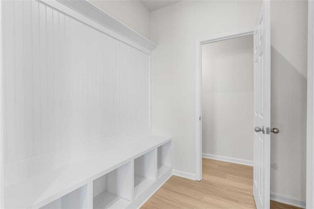 White mudroom featuring built-in bench, cubbies, and beadboard walls in Davidson Homes The Glenwood C at Wehunt Meadows, Hoschton, GA