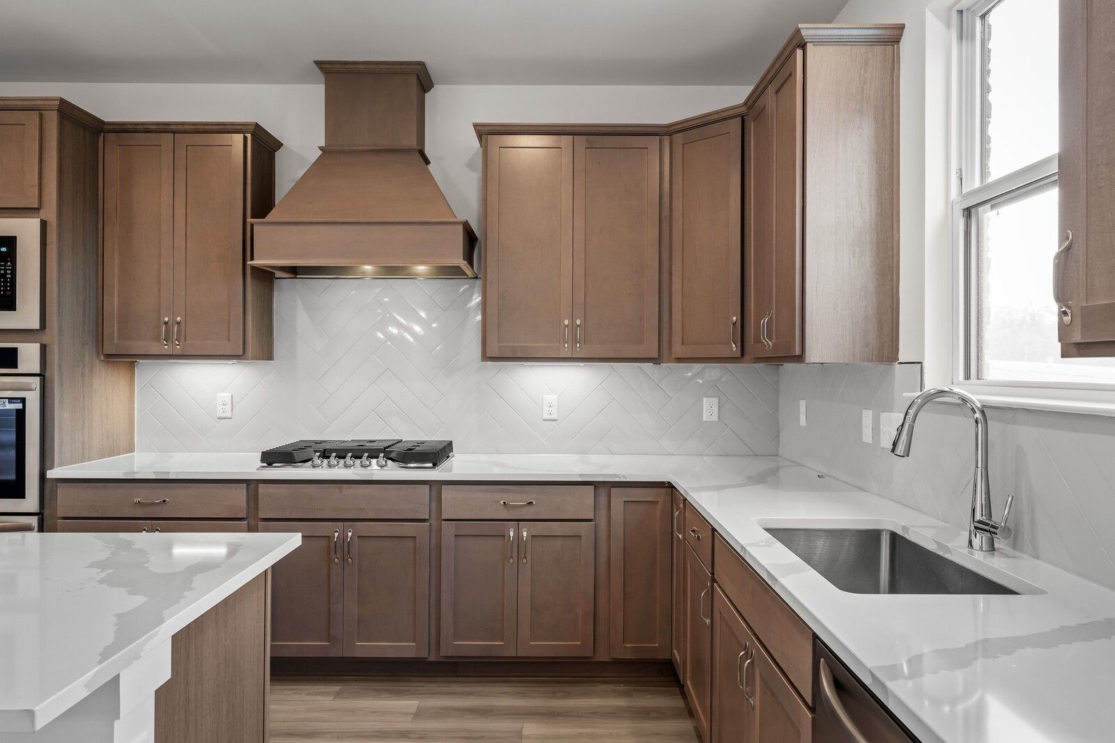 Modern kitchen with wooden cabinets, gas range, and quartz countertops in The Henry C floor plan, Benders Cove, Mt. Juliet.