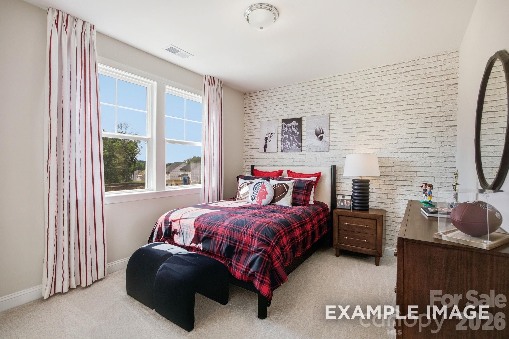 Football-themed bedroom with brick accent wall in The Hickory B II floor plan at Windgate, Mooresville, North Carolina.