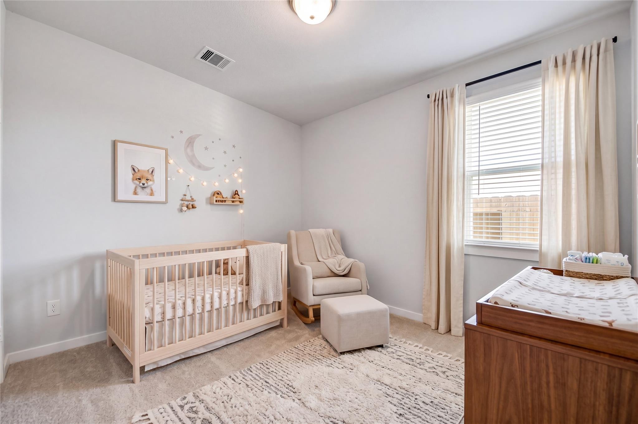 Cozy nursery bedroom with crib, rocking chair, and changing table in The Costa A floor plan by Davidson Homes in Beasley, Texas.