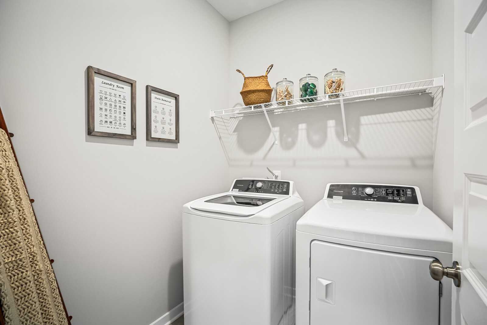 Spacious laundry room at Sage Farms in White House Tennessee with white washer dryer wire shelving and decorative baskets