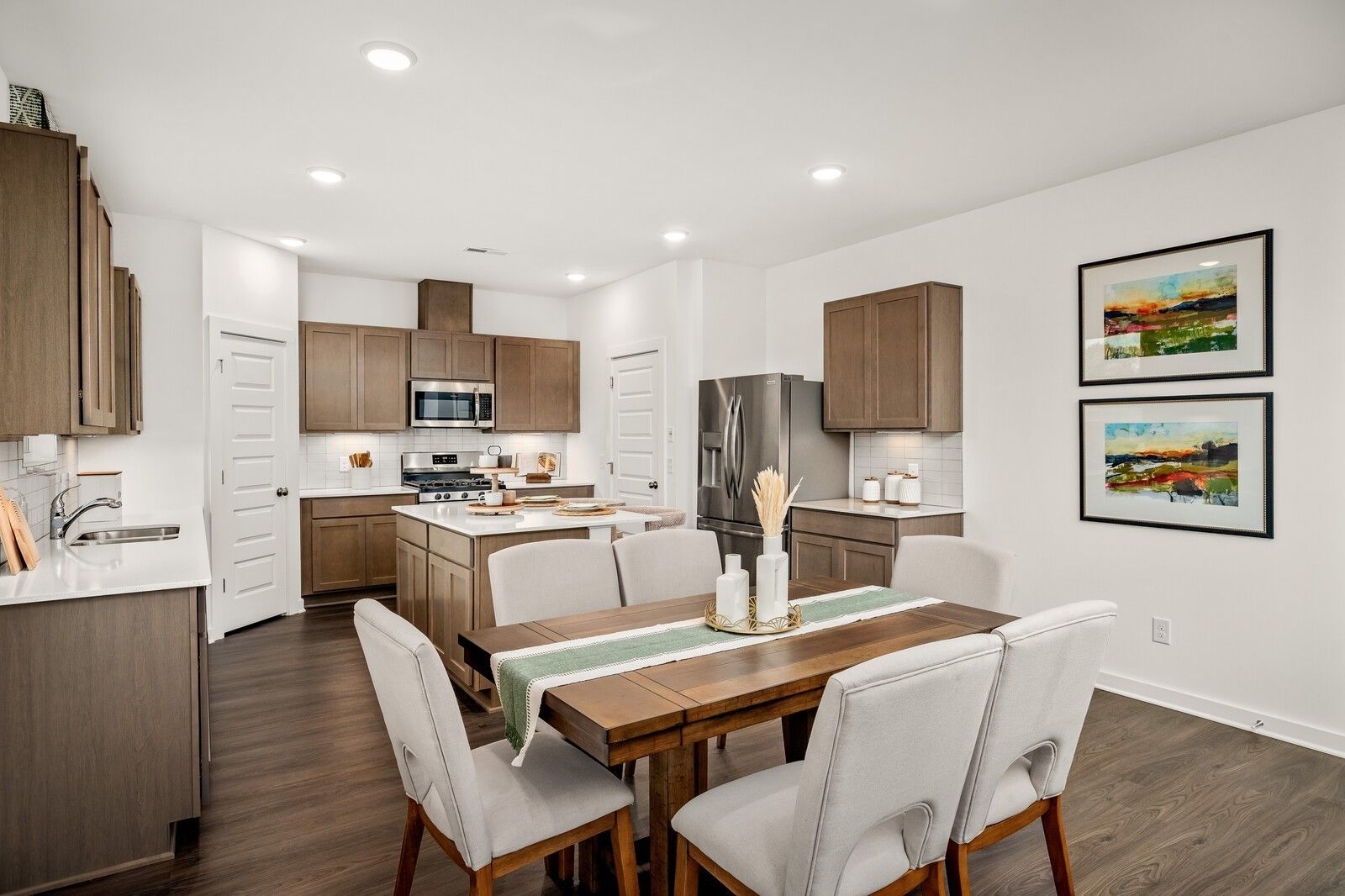 Open-concept kitchen with shaker cabinets, quartz counters, stainless appliances, and dining table in Davidson Homes The Gordon C, White House, TN