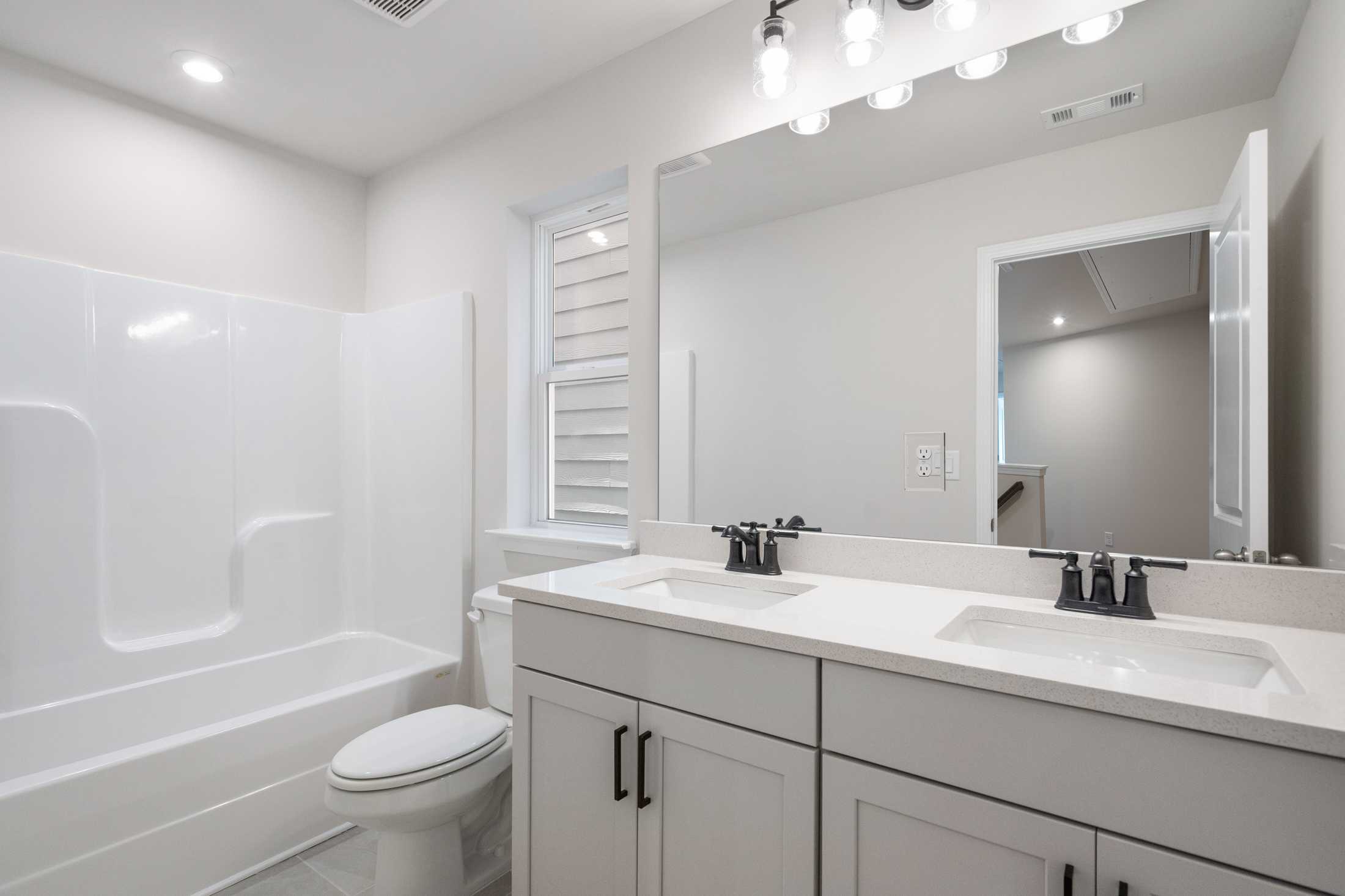 Spacious master bathroom in The Cary B featuring double vanity, soaking tub, walk-in shower, and neutral tones