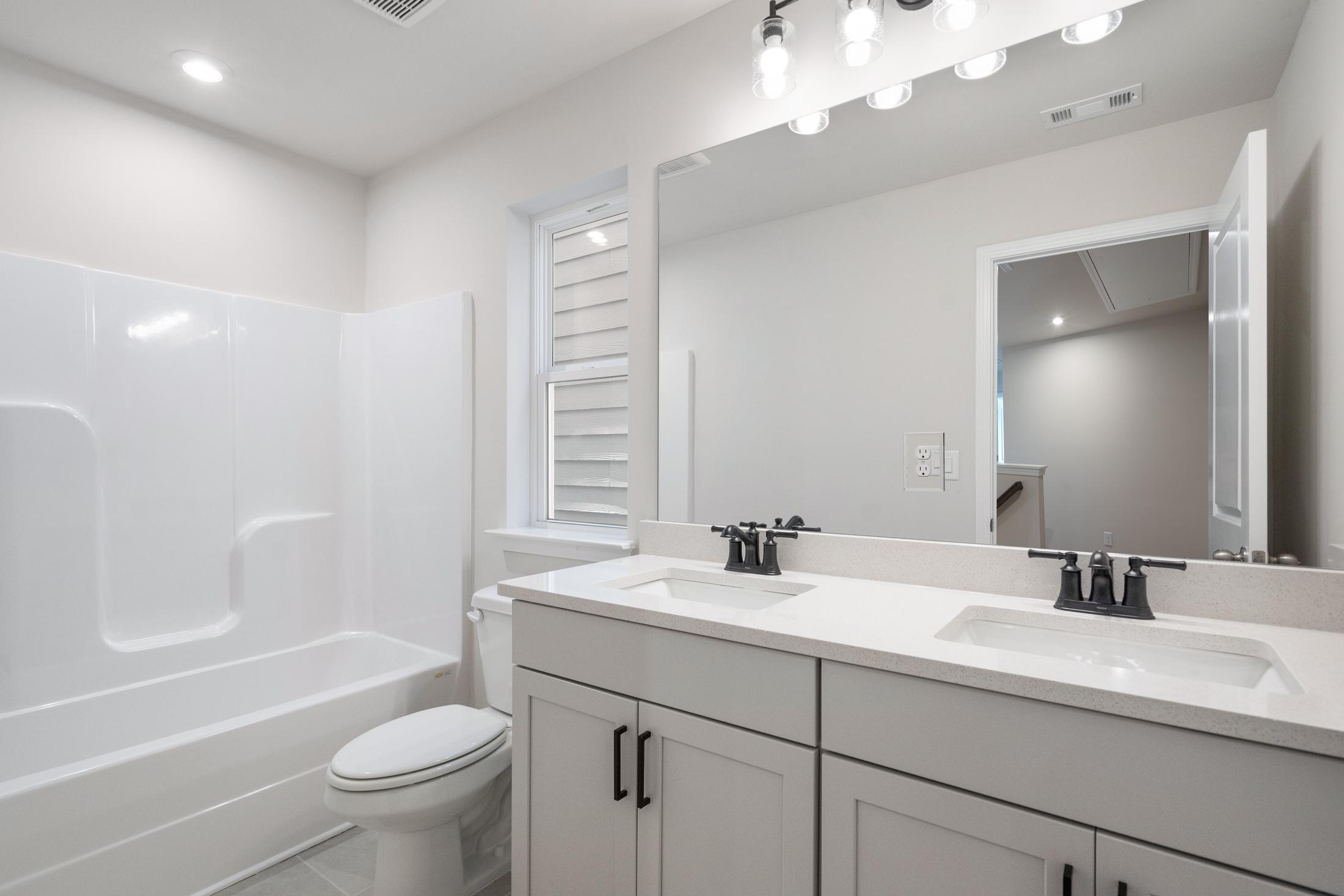 Spacious master bathroom in The Cary B featuring double vanity, soaking tub, walk-in shower, and neutral tones