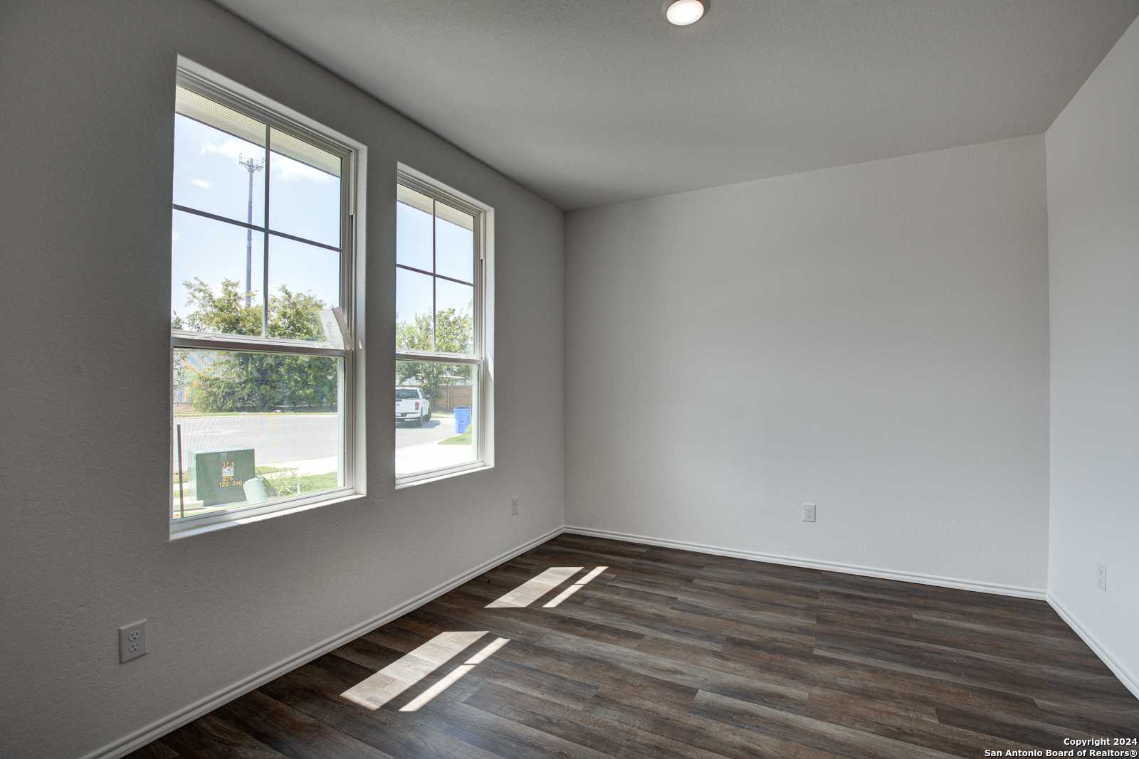 Bright bedroom with large sunny windows and laminate wood floors in Davidson Homes The Douglas D, Seguin