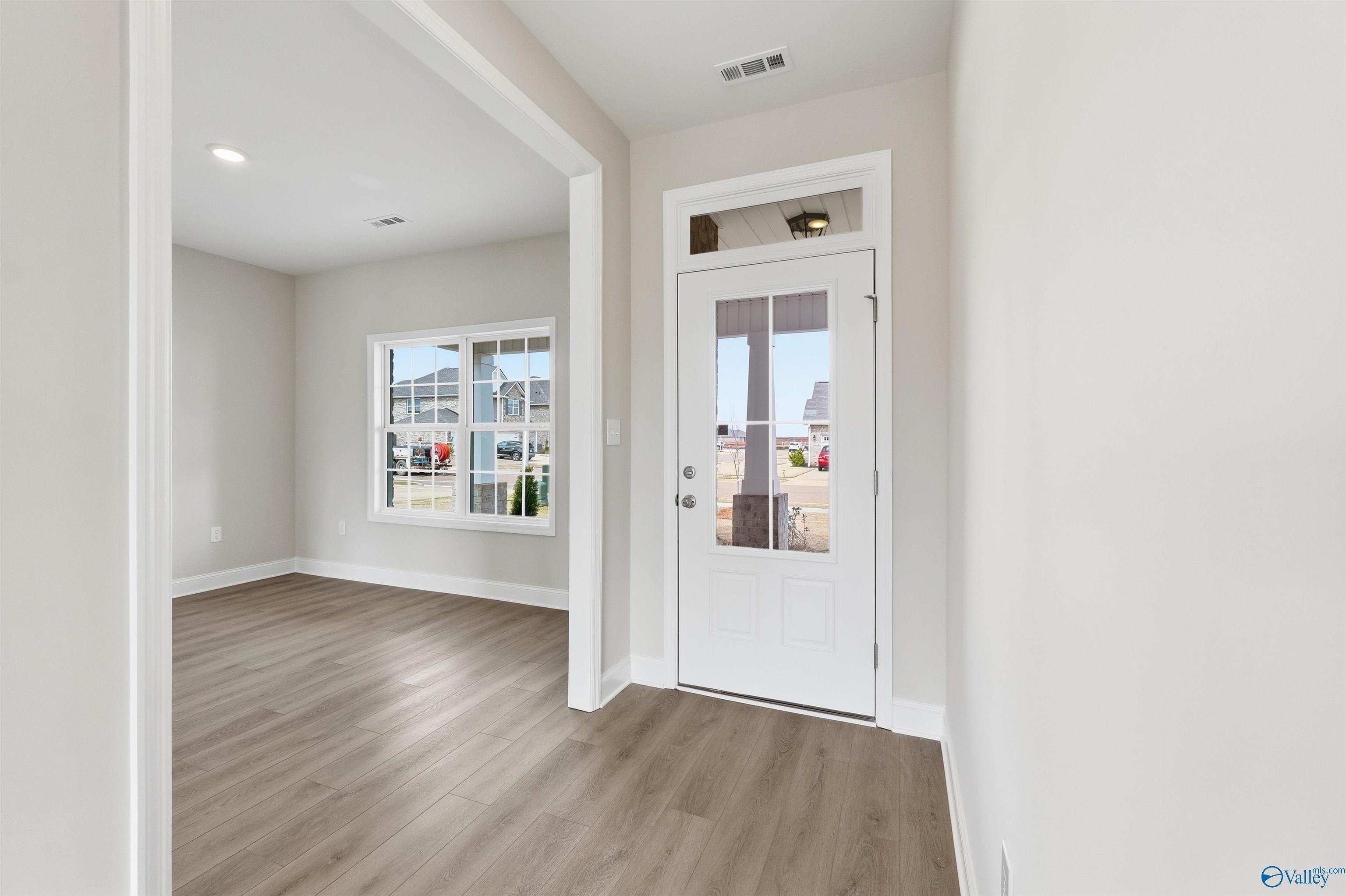 Bright entryway with luxury vinyl plank flooring and front door in The Shelby D plan at Evergreen Mill, Madison, Alabama.