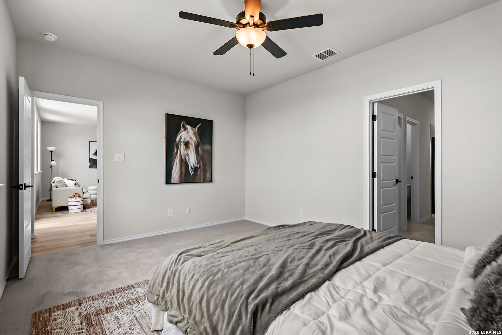 Spacious bedroom with neutral decor and horse wall art in The Douglas C floor plan at Hannah Heights, Seguin, Texas.