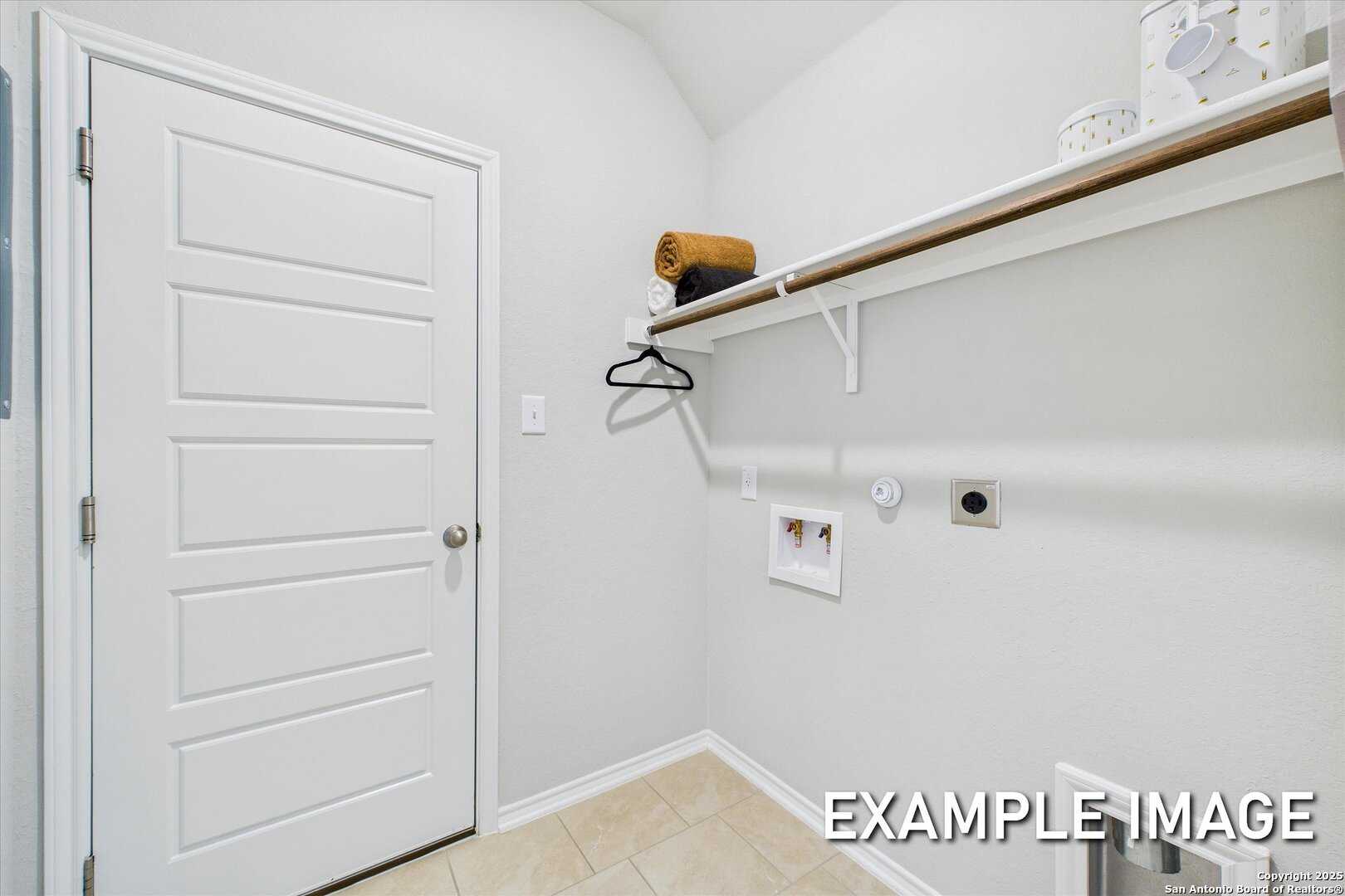 Spacious laundry room with washer, dryer, open shelves, and storage in Davidson Homes The Sabine C, Agave, San Antonio