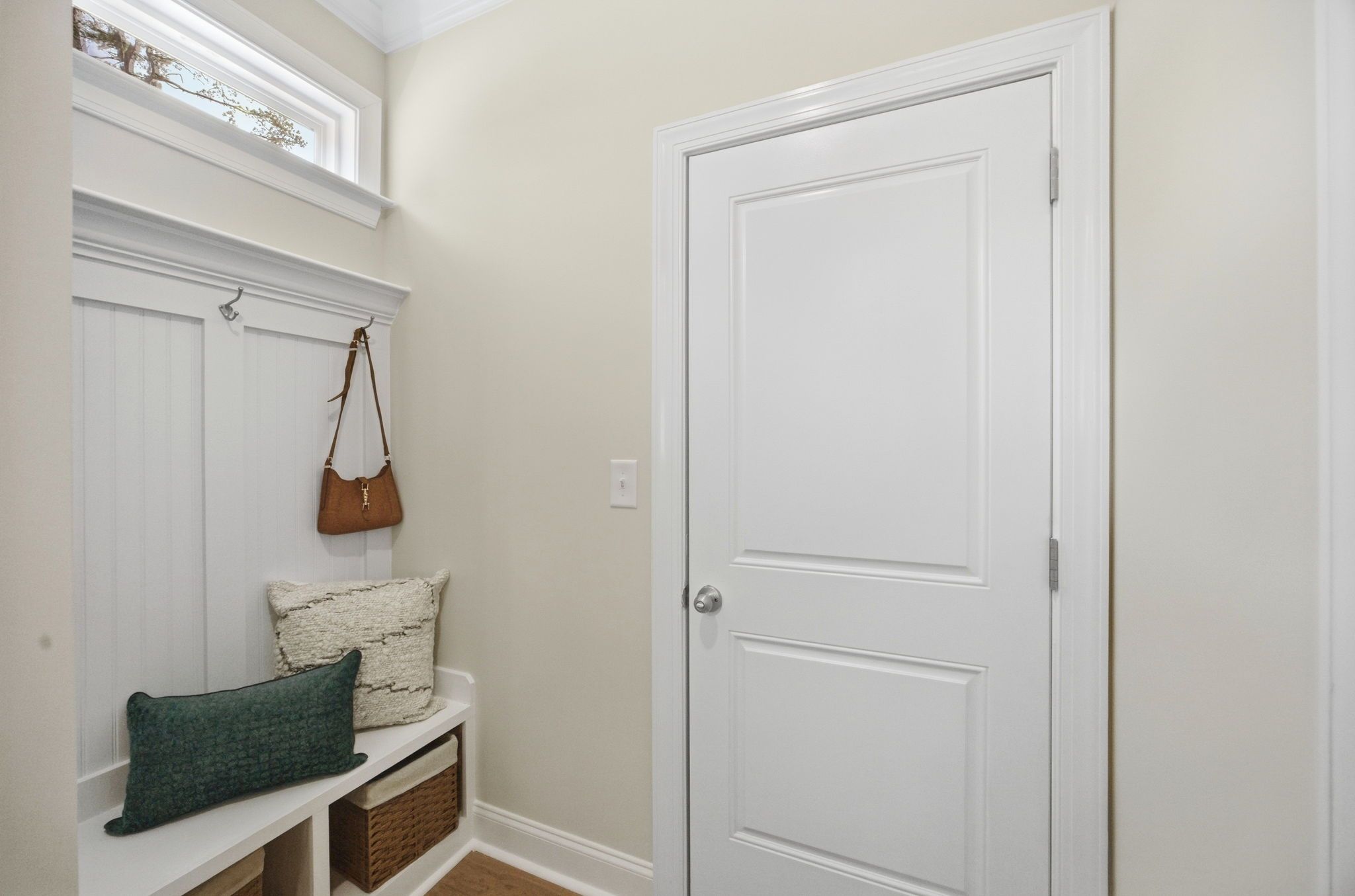 Mudroom entryway at Enclave at Belmont by Davidson Homes featuring built-in bench seating, coat hooks, and storage baskets.