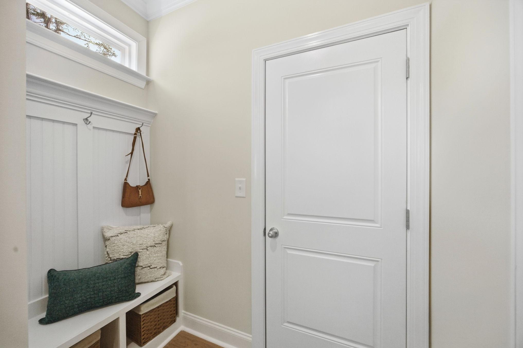 Mudroom entryway at Enclave at Belmont by Davidson Homes featuring built-in bench seating, coat hooks, and storage baskets.