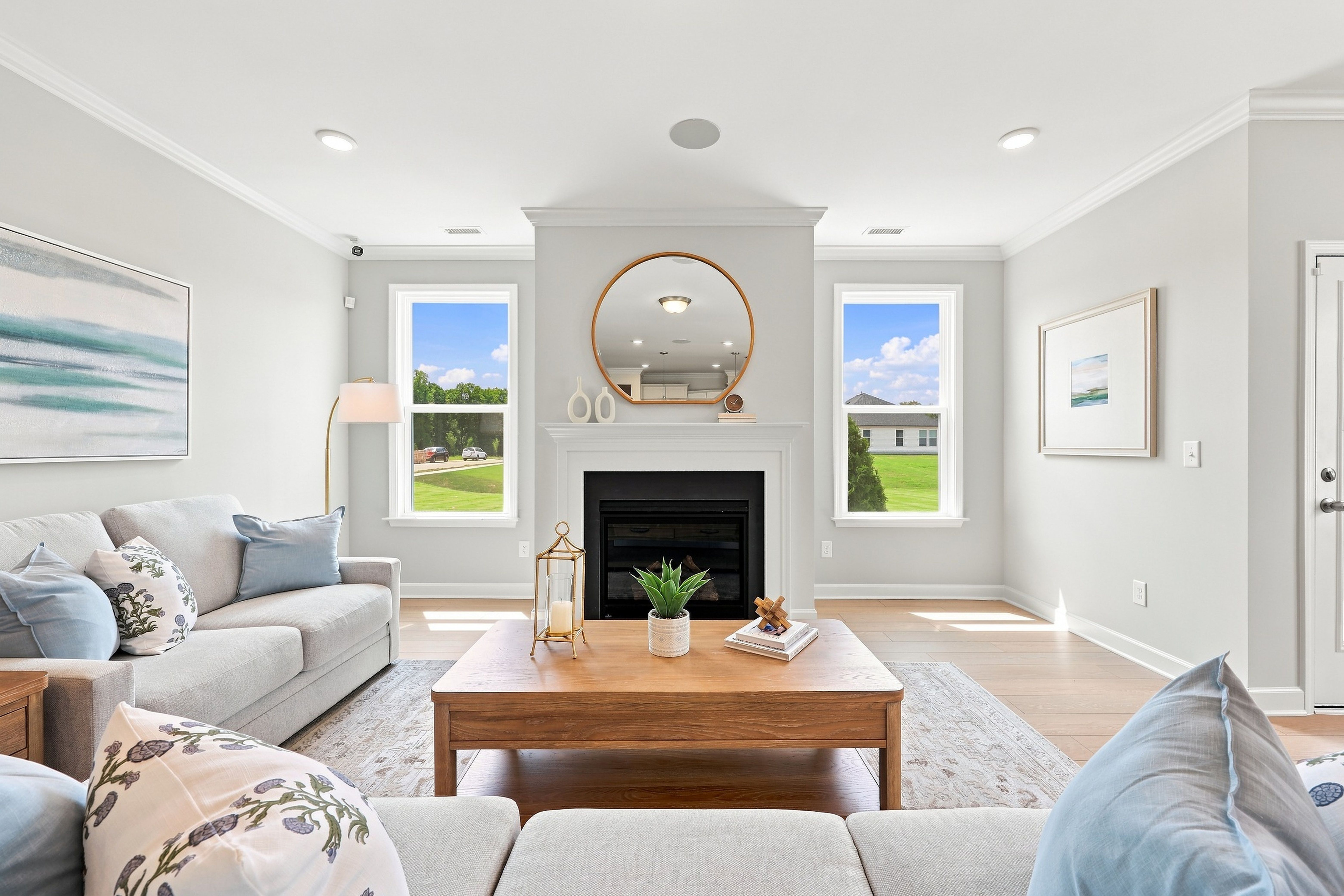 Bright living room in The Daphne C featuring a cozy fireplace, wood coffee table, and large windows with natural light.