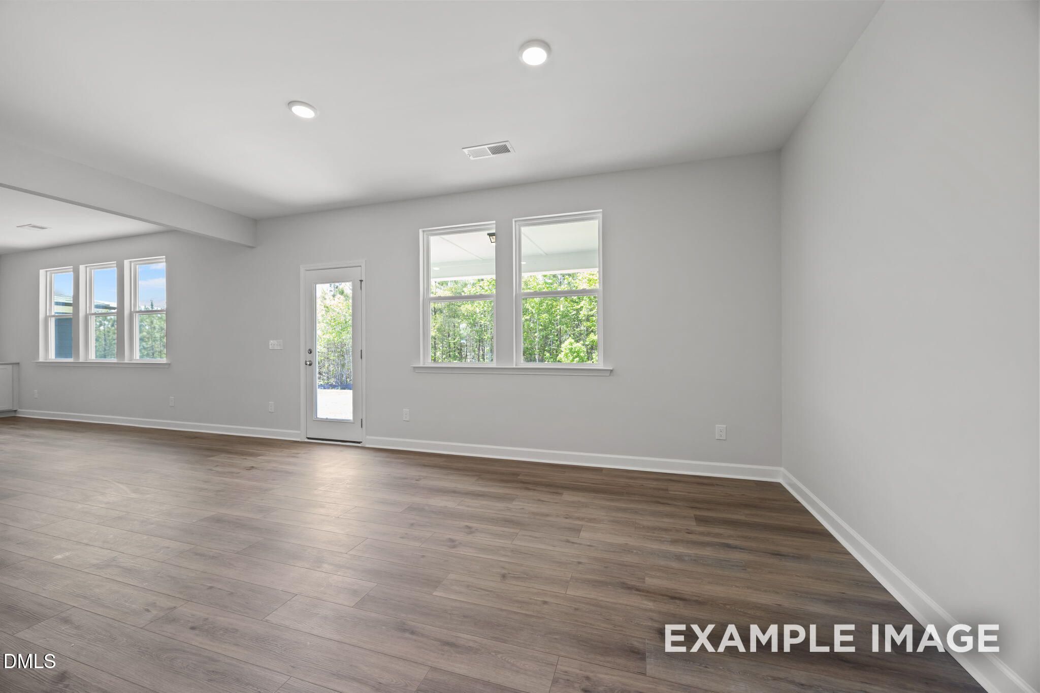 Bright open-concept living room with luxury vinyl plank flooring and backyard access in Davidson Homes The Beech, Wendell Ridge