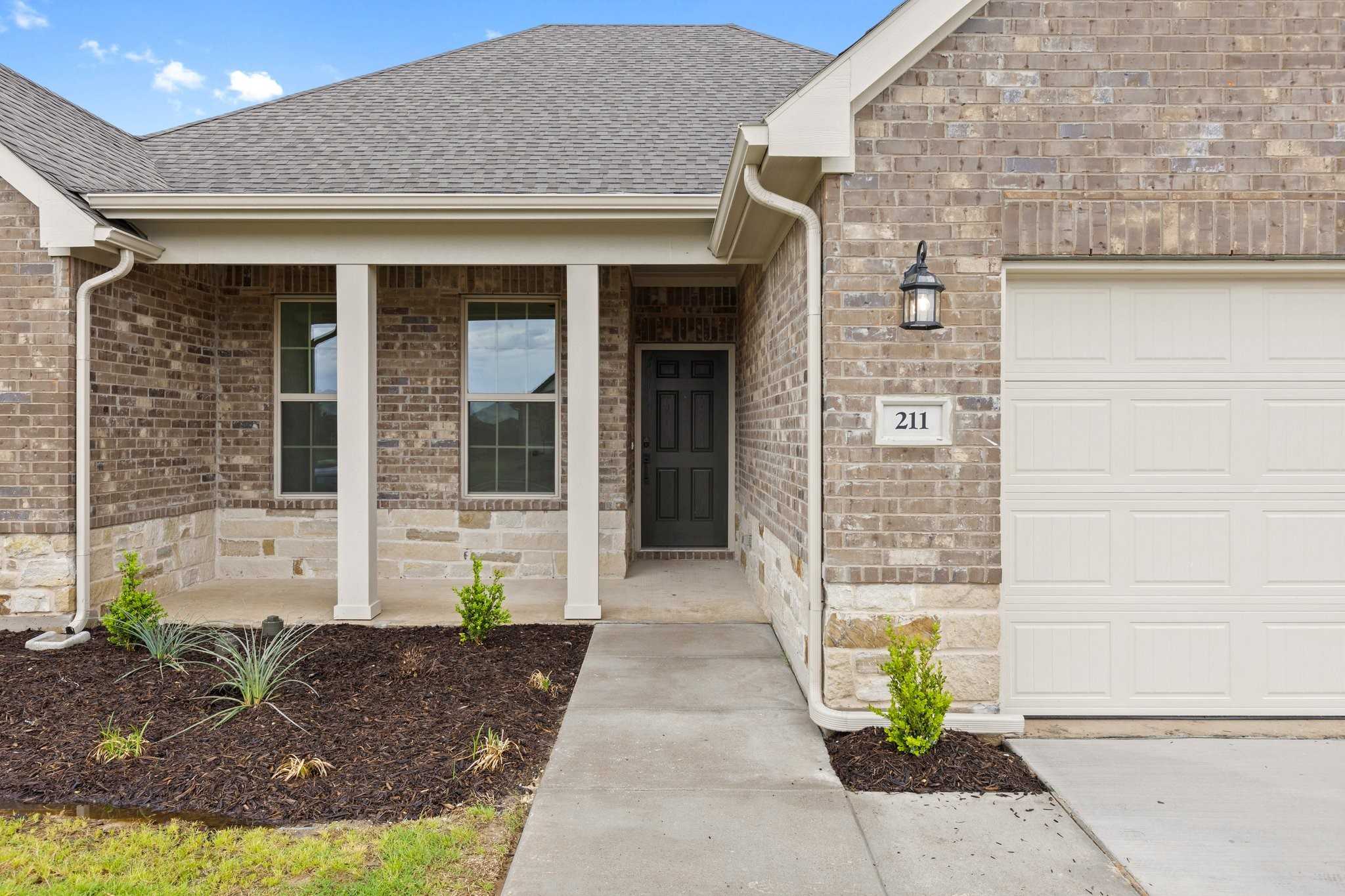 Brick ranch-style front of The Rockford C 4-bedroom home with covered porch, 3-car garage, and landscaped entry in Waverly Estates, Josephine, Texas