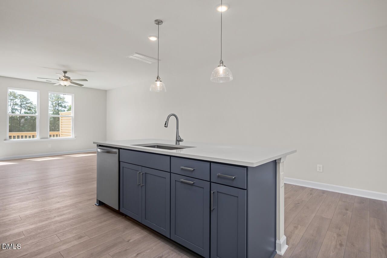 Modern blue kitchen island with pendant lighting in The Mitchell floor plan by Davidson Homes in Camden Park, Knightdale, NC.
