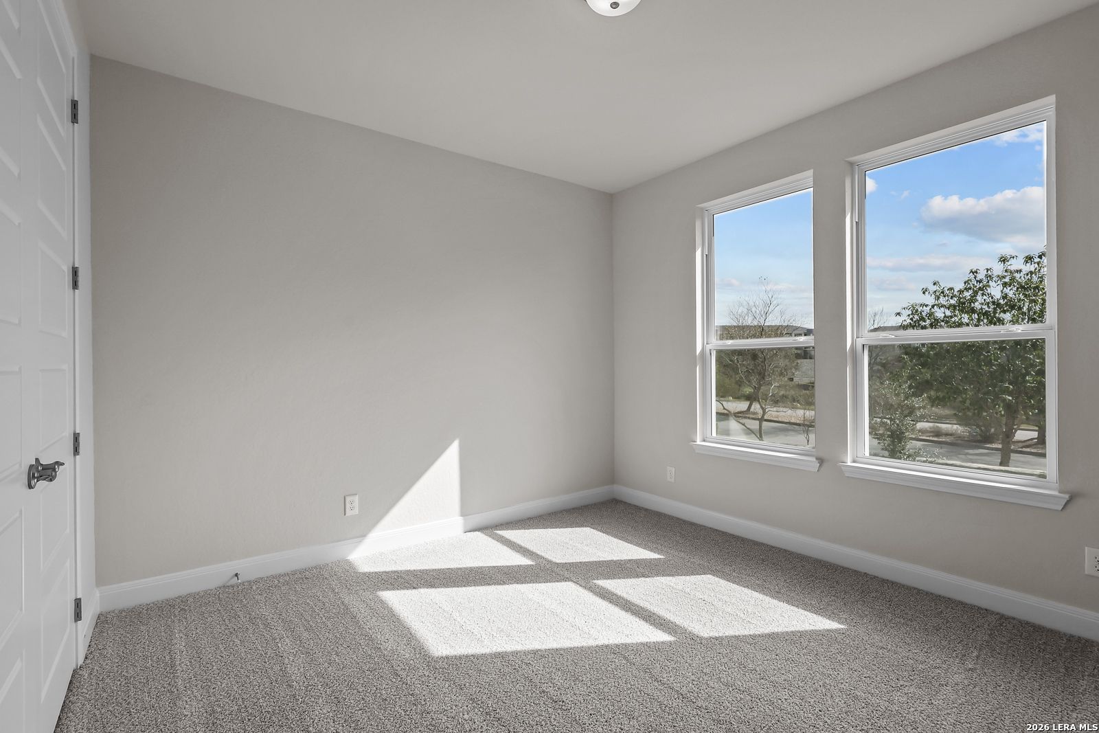 Bright bedroom with neutral carpet and natural light in The Lanier H floor plan by Davidson Homes in Ladera, San Antonio.