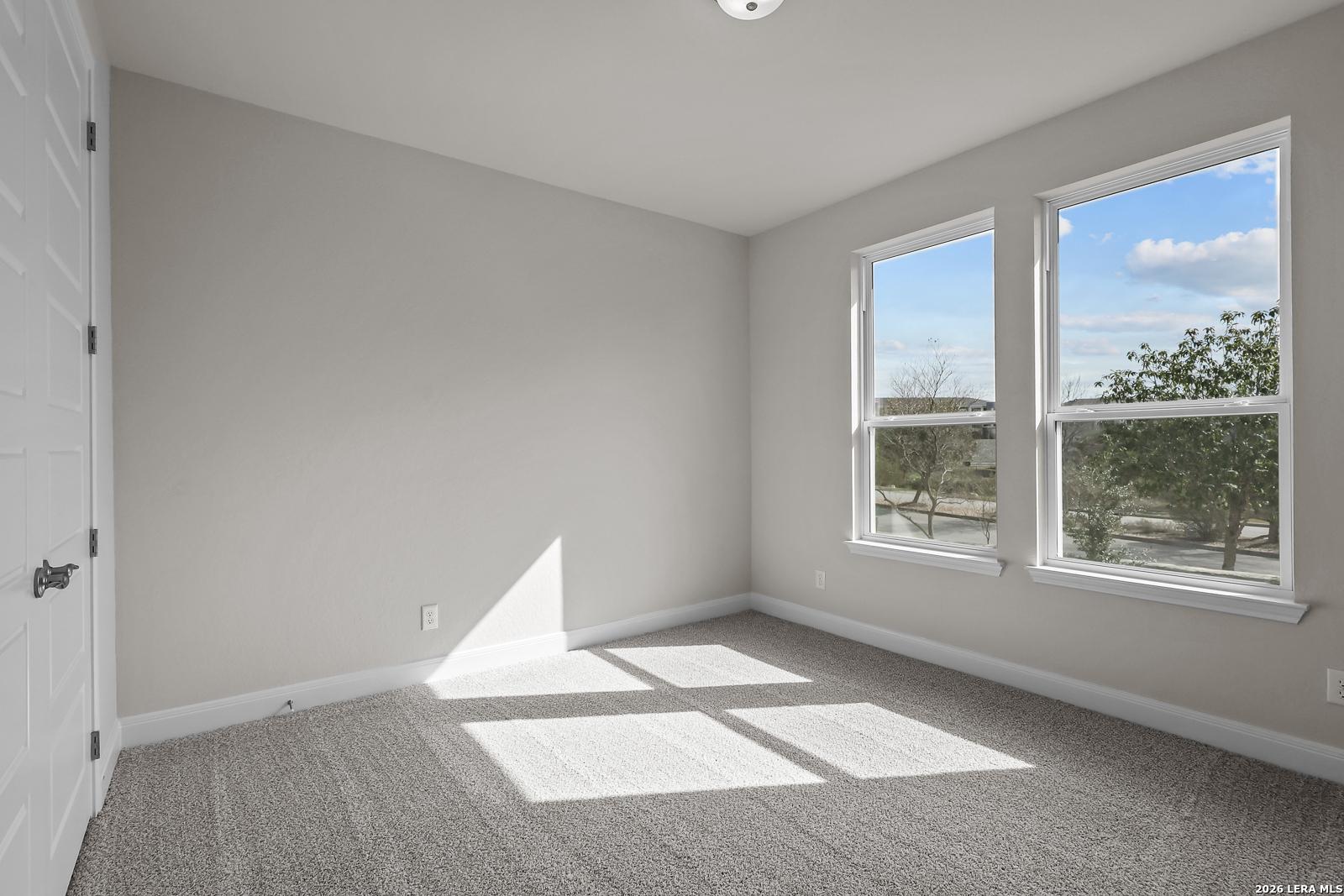 Bright bedroom with neutral carpet and natural light in The Lanier H floor plan by Davidson Homes in Ladera, San Antonio.