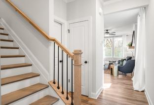 Spacious oak staircase with black balusters in The Washington H townhome, open to airy living area, Davidson Homes Marietta GA