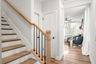 Spacious oak staircase with black balusters in The Washington H townhome, open to airy living area, Davidson Homes Marietta GA