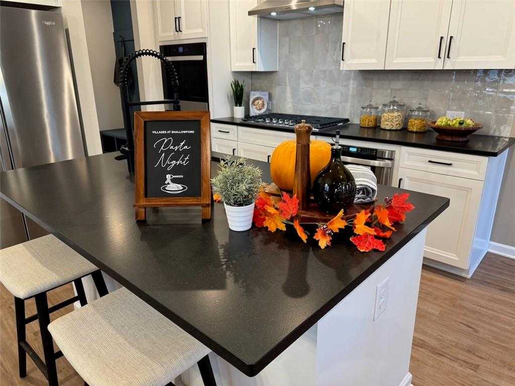 Modern kitchen island with fall decor, pumpkins, 'Pumpkin Night' sign, white cabinets in Davidson Homes The Marion B, Kennesaw, GA