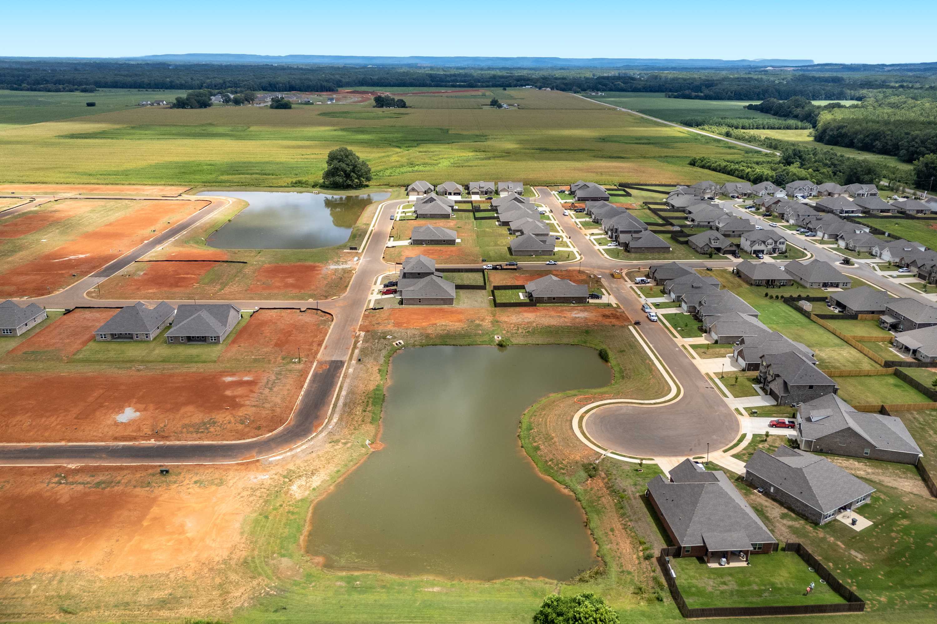 Aerial view of Kendall Downs in Toney Alabama with new single-story homes, retention ponds, and surrounding farmland