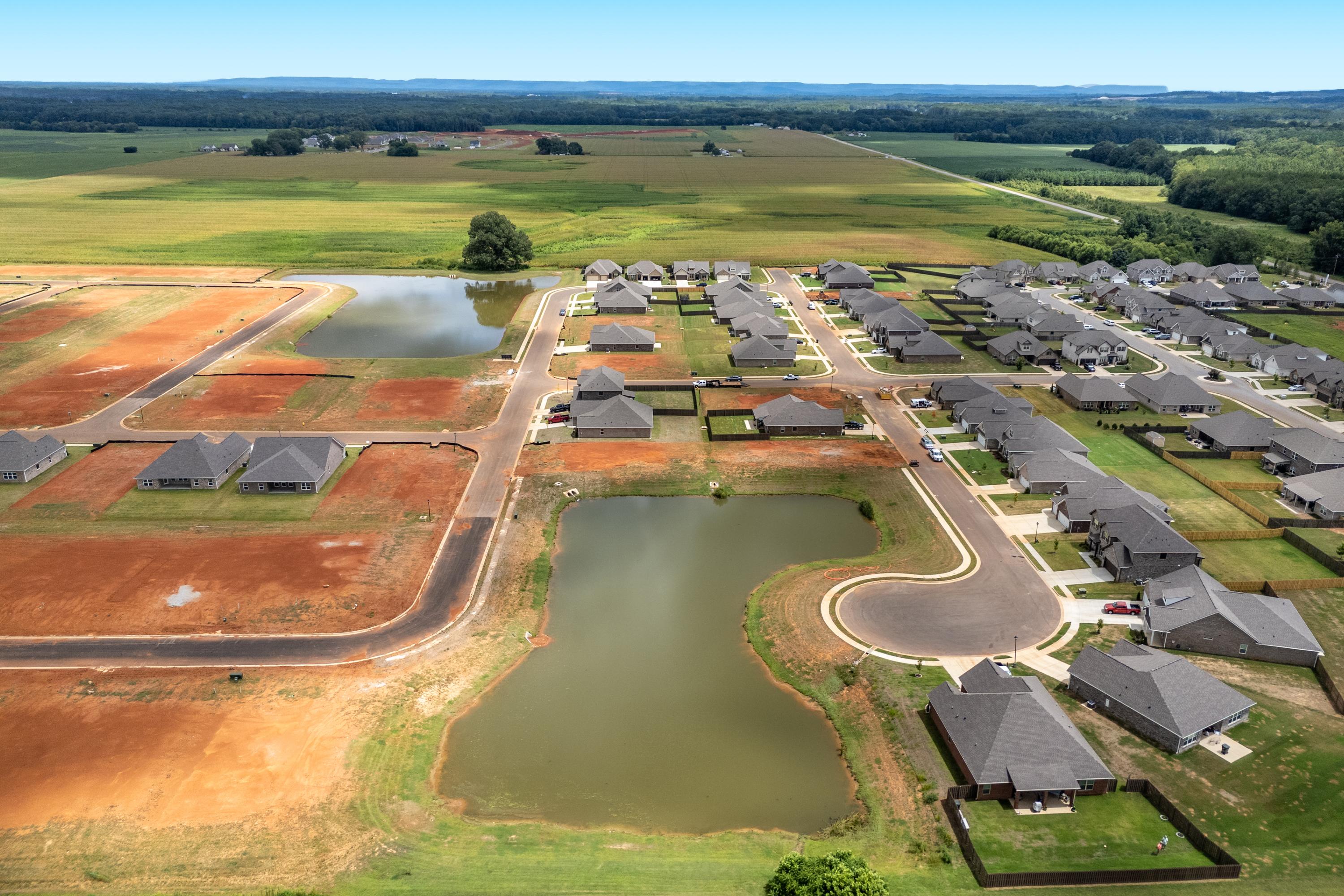 Aerial view of Kendall Downs in Toney Alabama with new single-story homes, retention ponds, and surrounding farmland