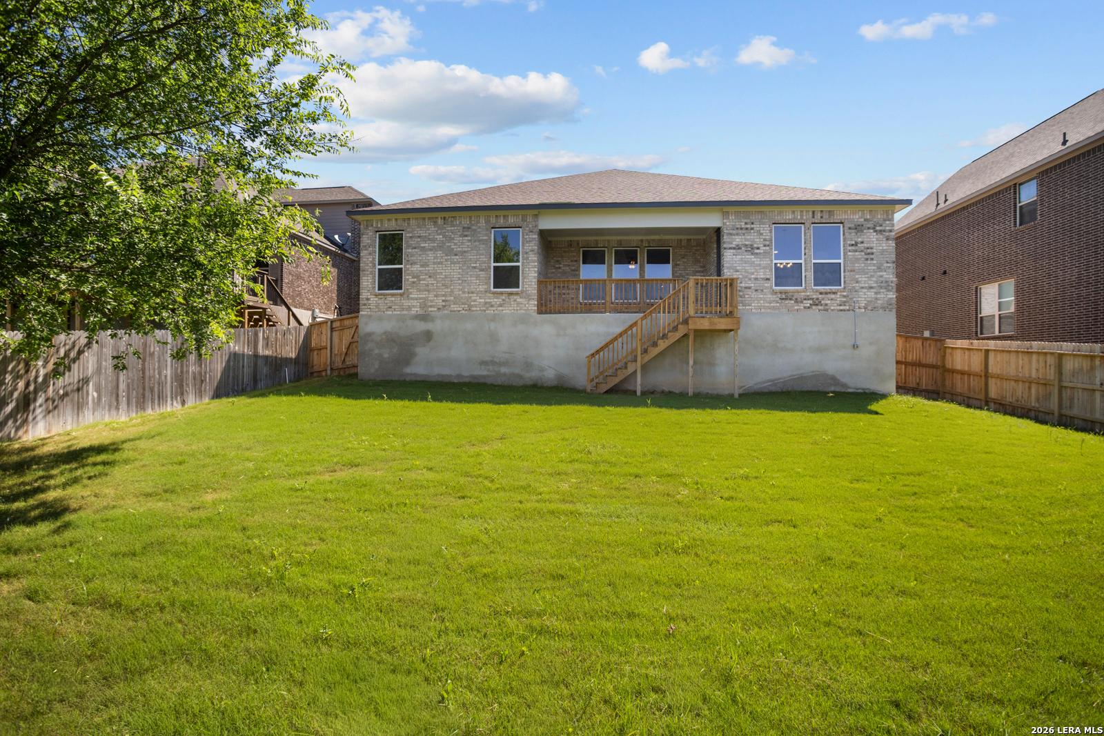 Backyard view of The Jennings G floor plan by Davidson Homes in Ladera, San Antonio, featuring a wood deck and fenced yard.
