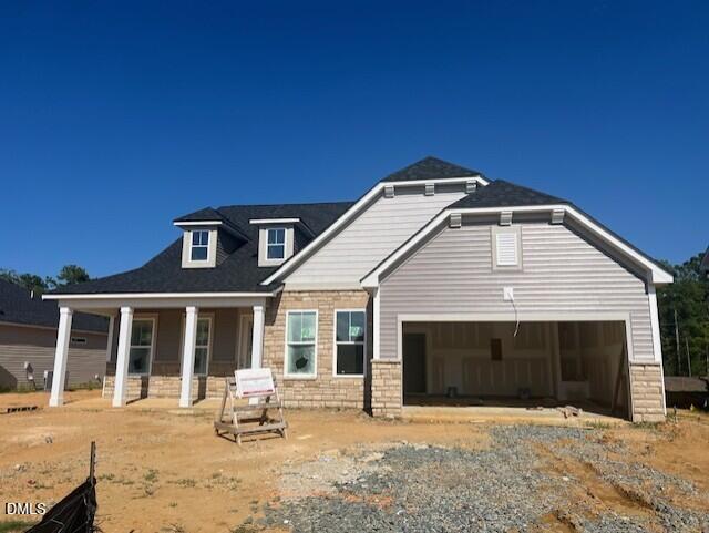 New construction single-story home with stone accents, covered porch, and 2-car garage by Davidson Homes in Lillington, NC