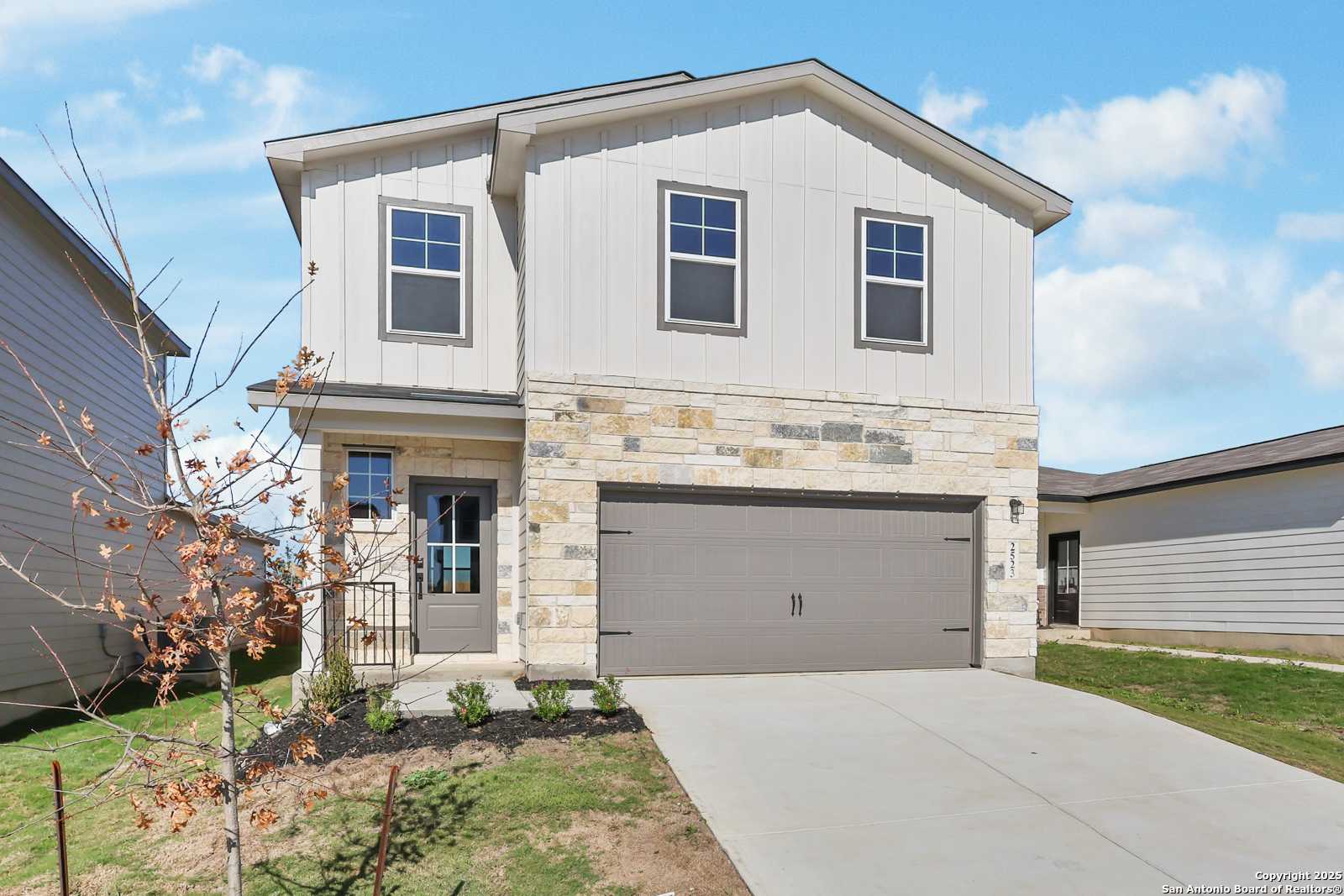 Two-story Davidson Homes The Brazos C with stone accents, 2-car garage, and landscaped front yard in Applewhite Meadows, San Antonio