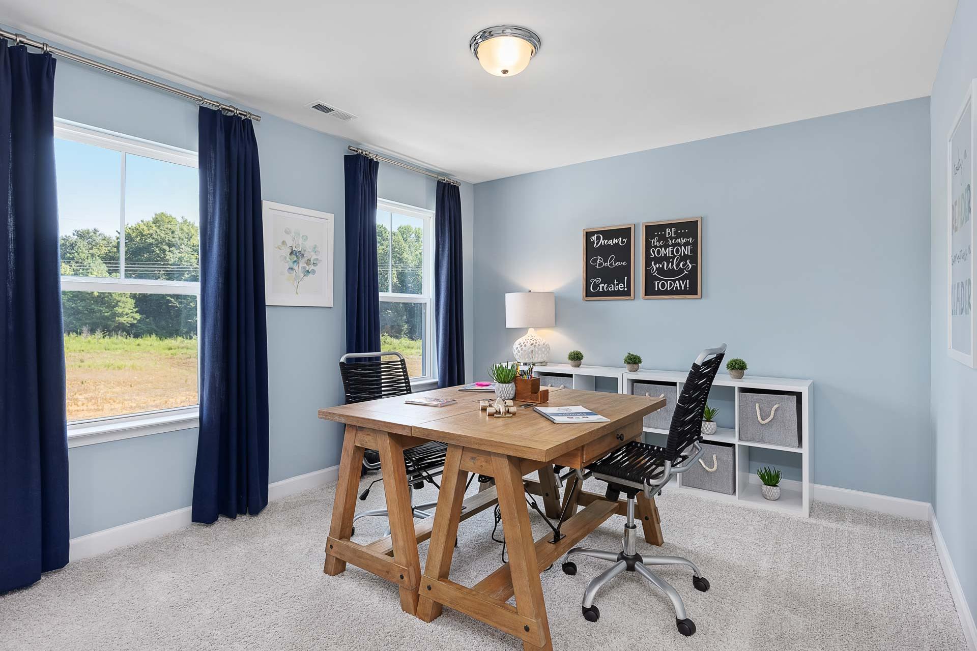 Cozy home office in Highland Forest, Fuquay-Varina NC with rustic wood desk, blue walls, large windows, and plants