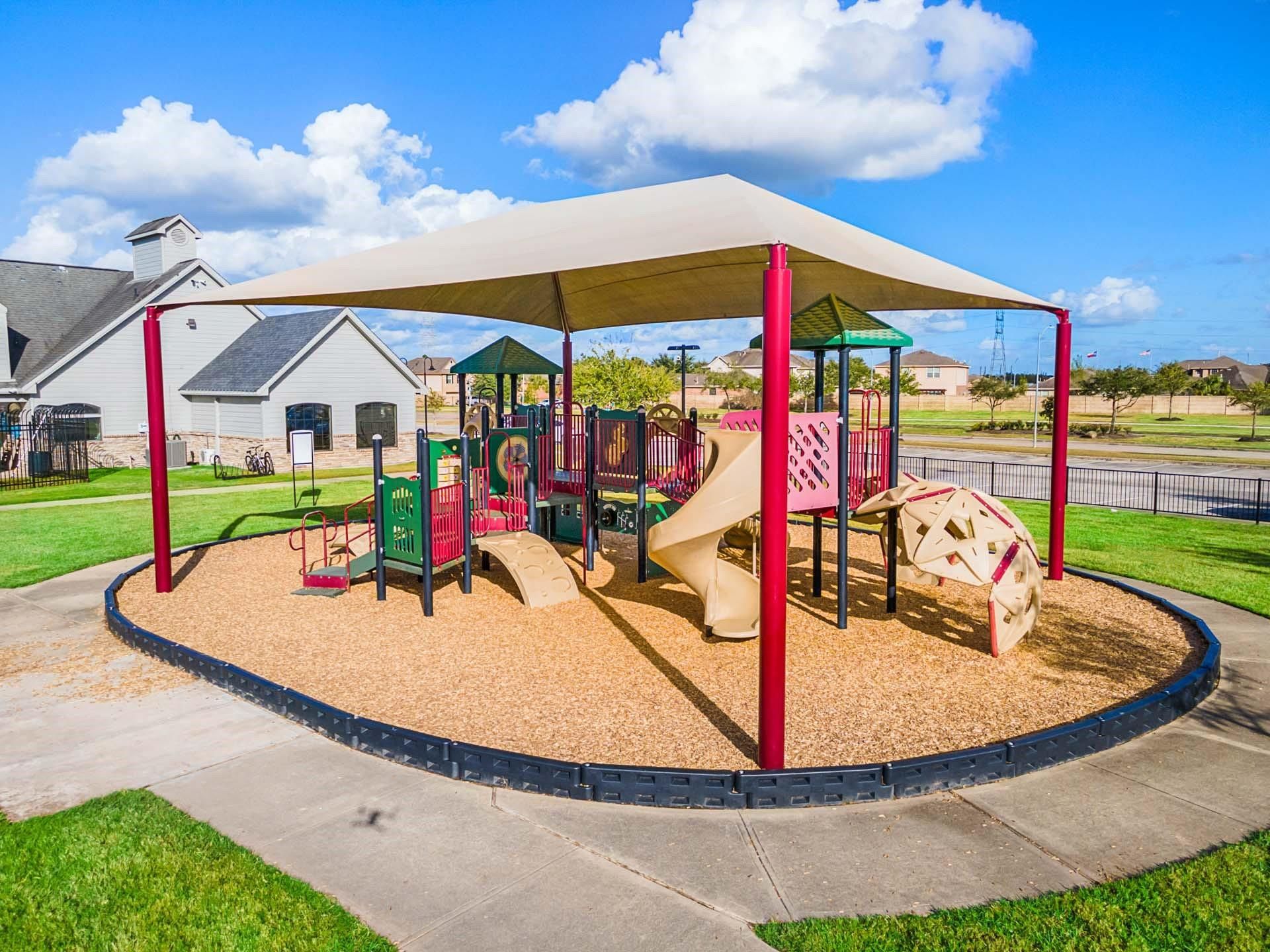 Community playground with shaded structures at Sierra Vista master-planned community in Rosharon, Texas.