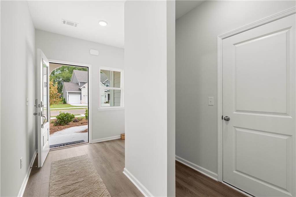Bright entryway with modern wood-style flooring in The Sinclair B floor plan at Cedar Farms in Winder, Georgia.