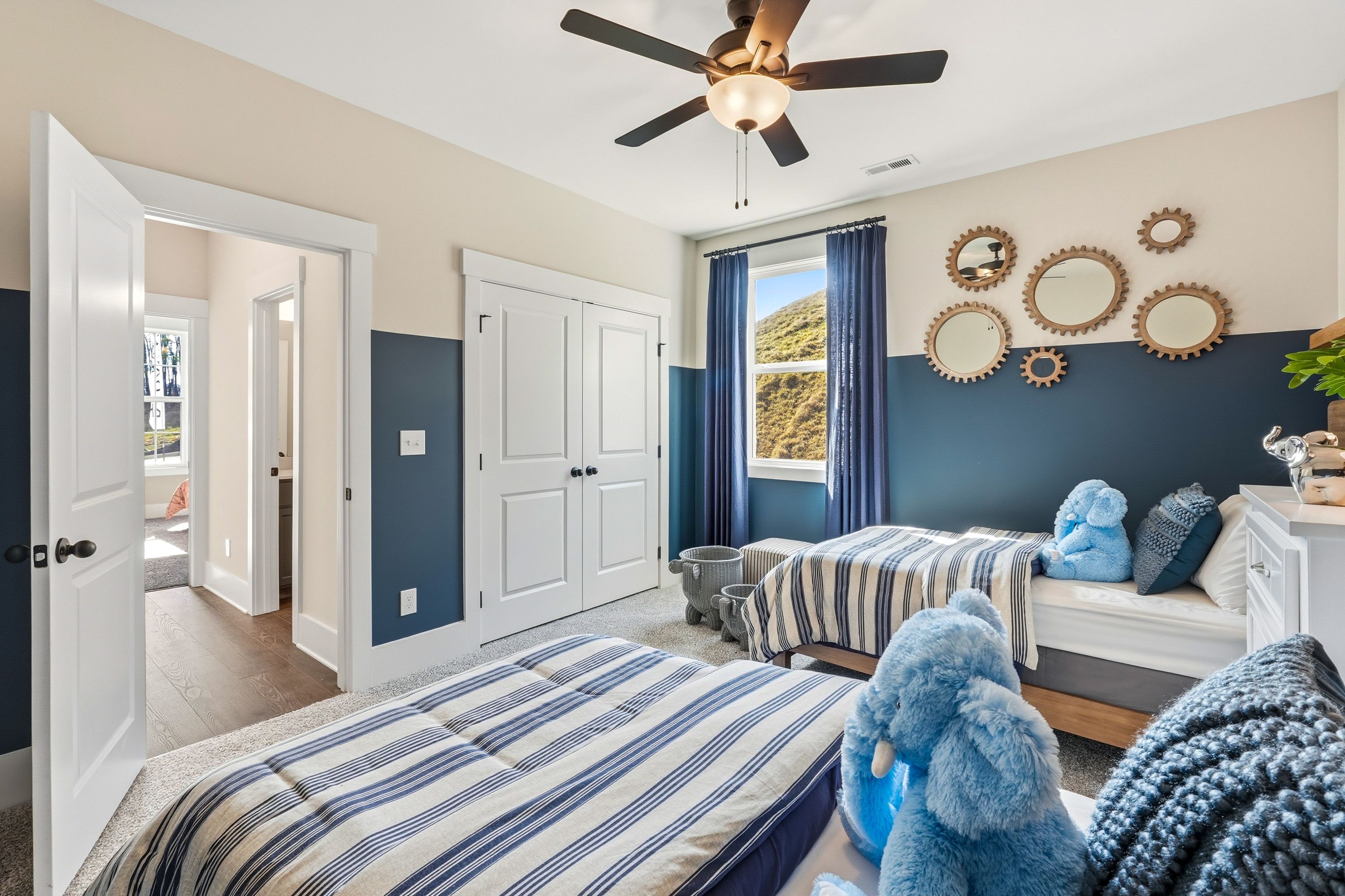 Nautical boys' bedroom at Noble Ridge in Cullman Alabama with twin beds, elephant pillows, striped bedding, and decorative mirrors