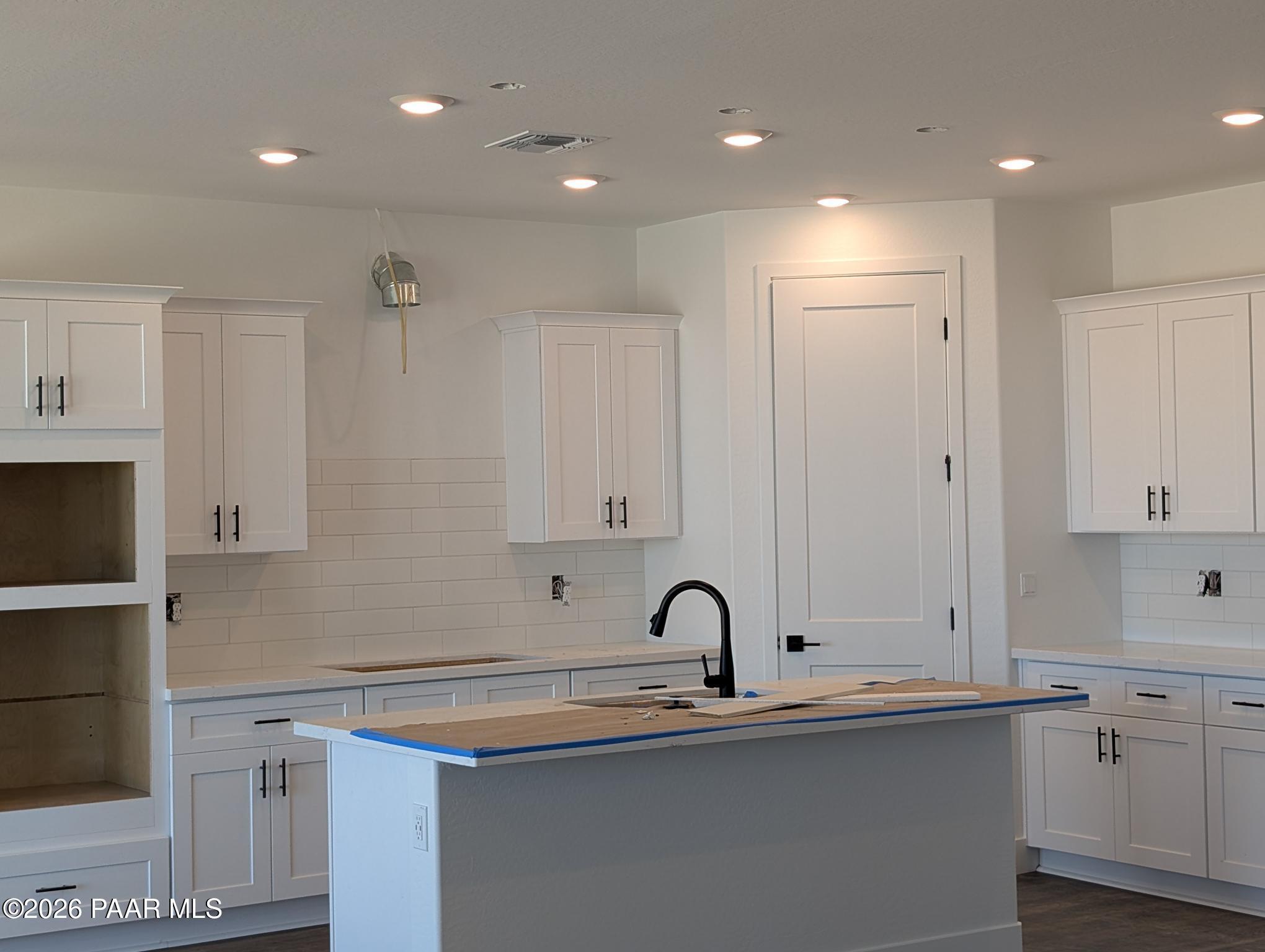 Modern kitchen with white shaker cabinets, subway tile backsplash, and island in Durango II G floor plan, Prescott, AZ.