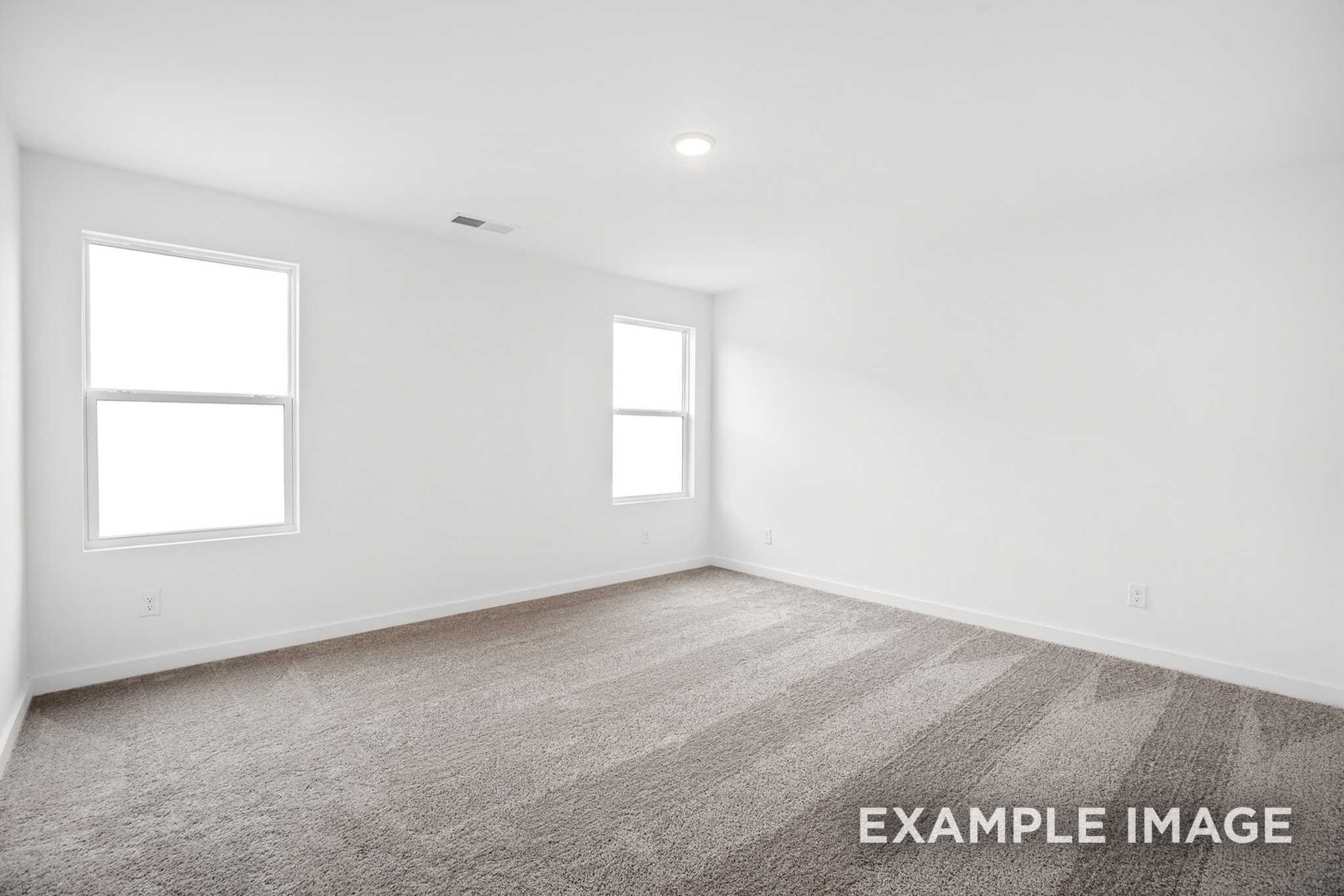 Spacious upper-floor bedroom in The Grayson C with gray carpet, white walls, large windows, and natural light