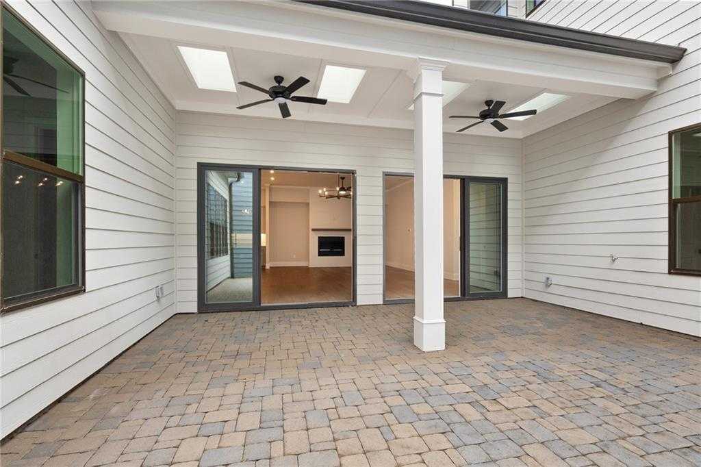 Covered patio with paver flooring, skylights, ceiling fans, and open glass doors to living area in Davidson Homes The Seaside B, Woodstock, GA