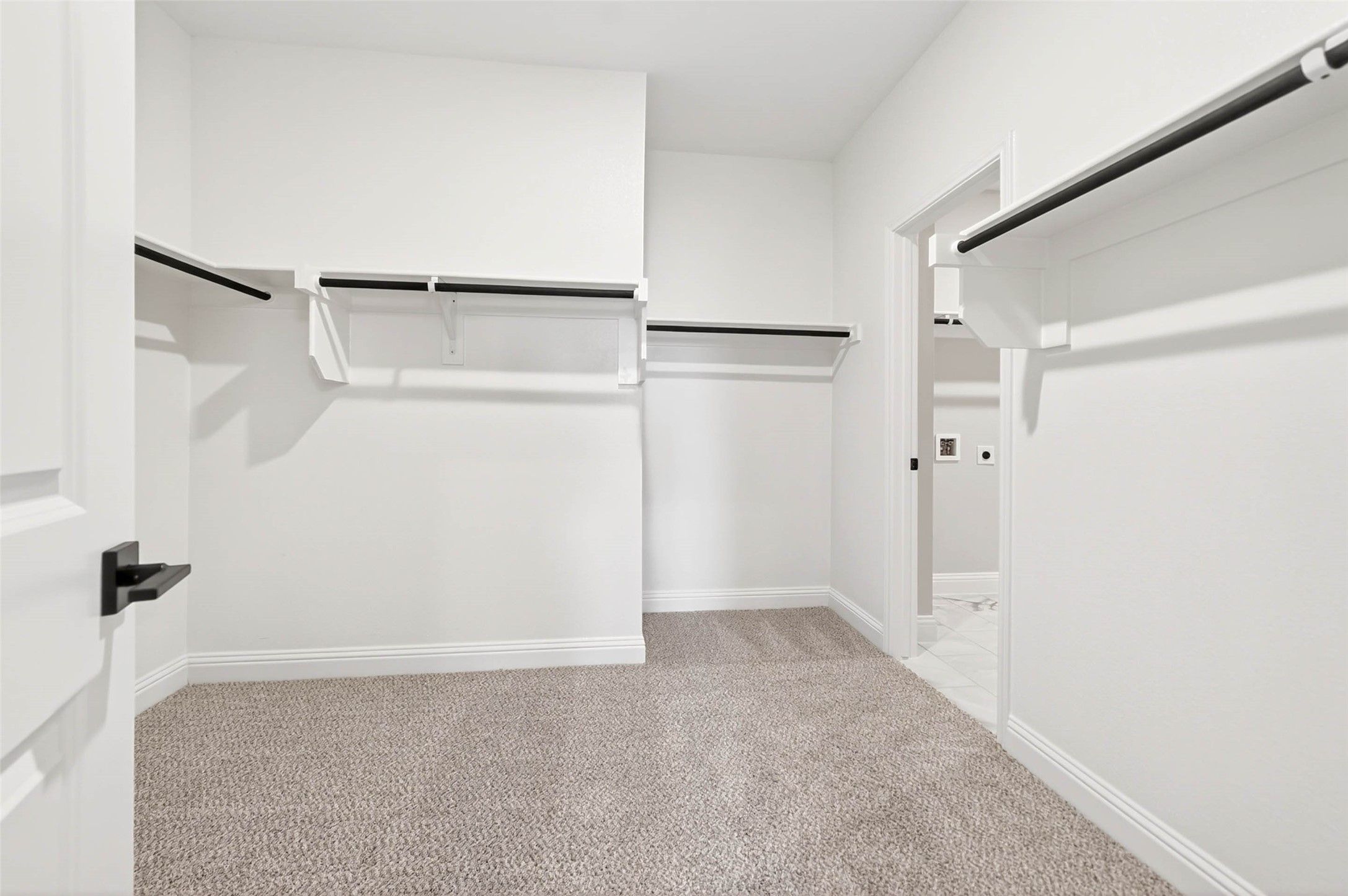 Spacious walk-in closet with carpet and shelving in The Holly C floor plan by Davidson Homes, Anna, Texas.