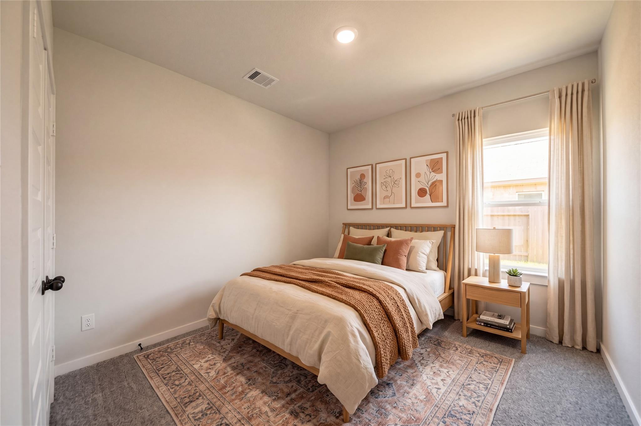Cozy secondary bedroom with neutral decor in The Riviera C floor plan at River Ranch Meadows, Dayton, Texas.