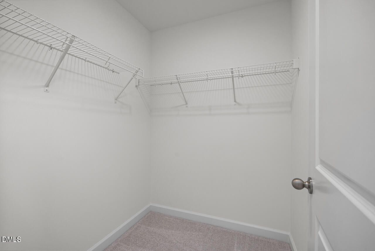 Walk-in closet with white wire shelving in The Grace C floor plan at Retreat at North Main in Lillington, NC.