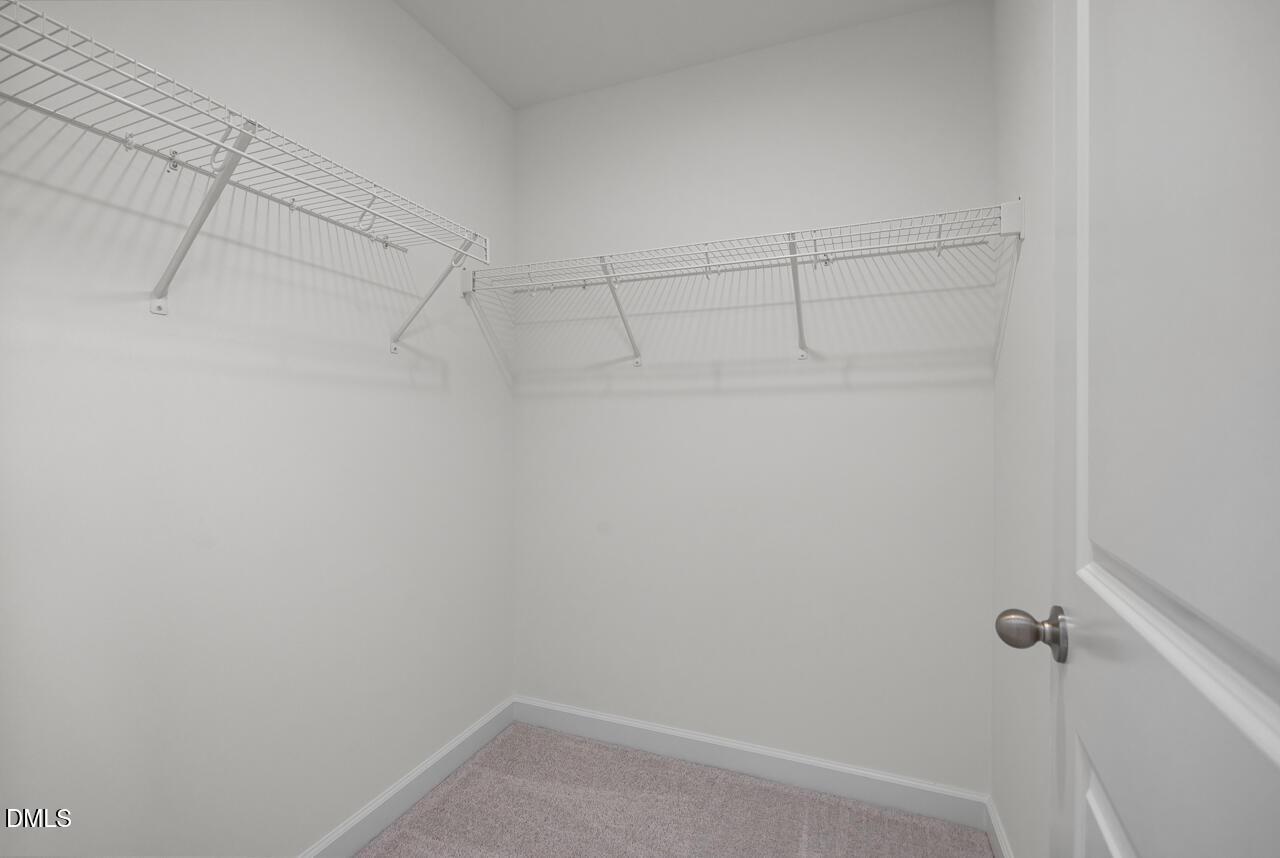 Walk-in closet with white wire shelving in The Grace C floor plan at Retreat at North Main in Lillington, NC.