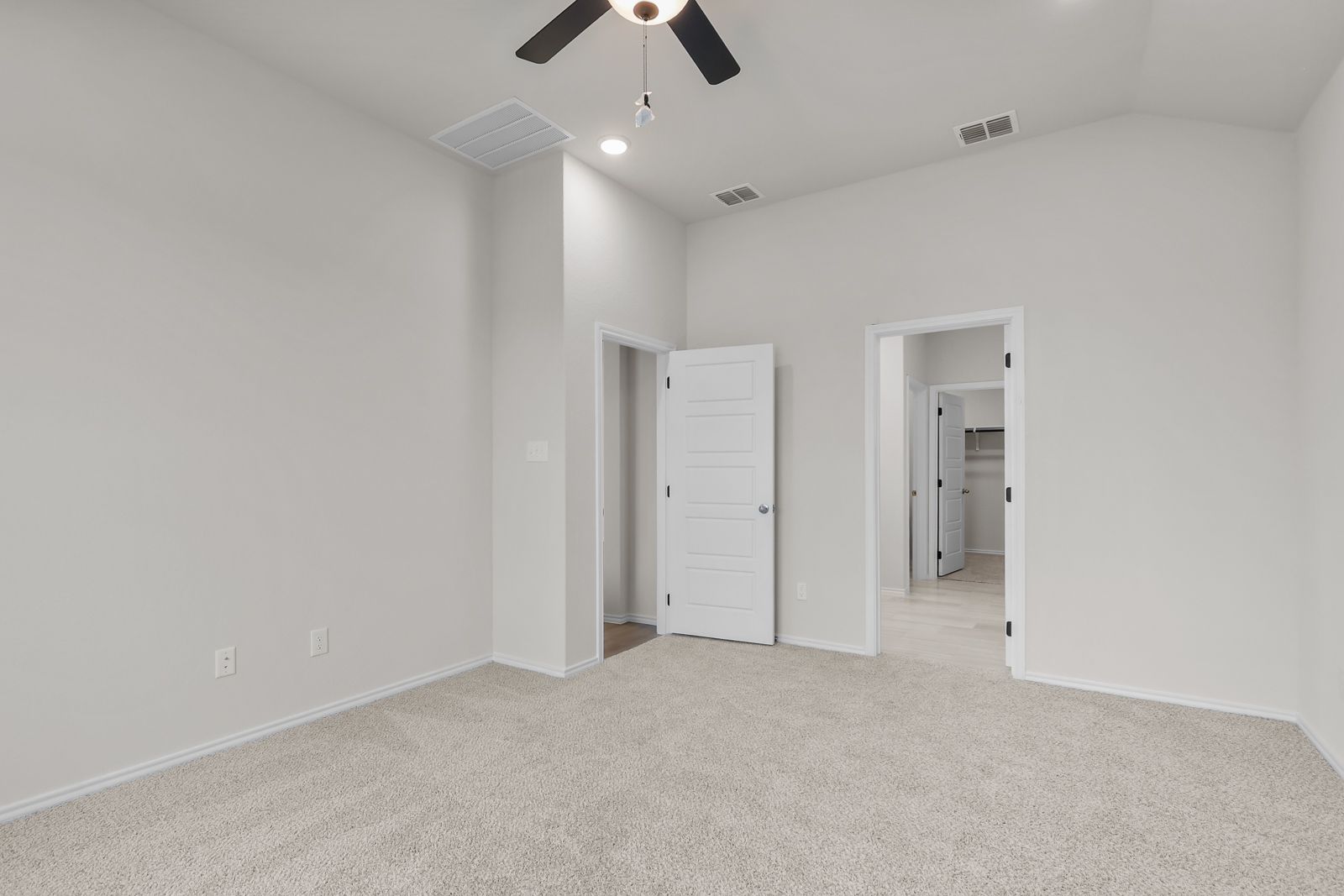 Spacious bedroom with neutral carpet in The Sequoia C floor plan by Davidson Homes in Converse, Texas.