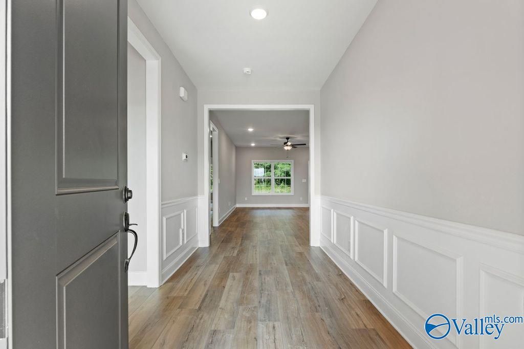 Elegant hallway with hardwood floors, wainscoted walls, and natural light in Davidson Homes The Montgomery B, Hartselle, AL
