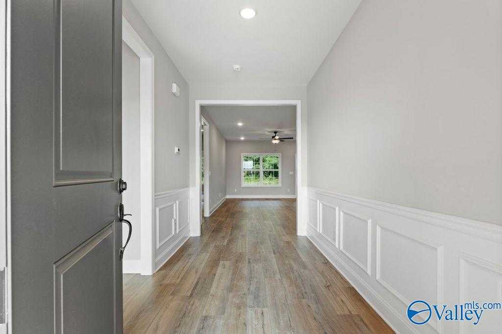 Elegant hallway with hardwood floors, wainscoted walls, and natural light in Davidson Homes The Montgomery B, Hartselle, AL
