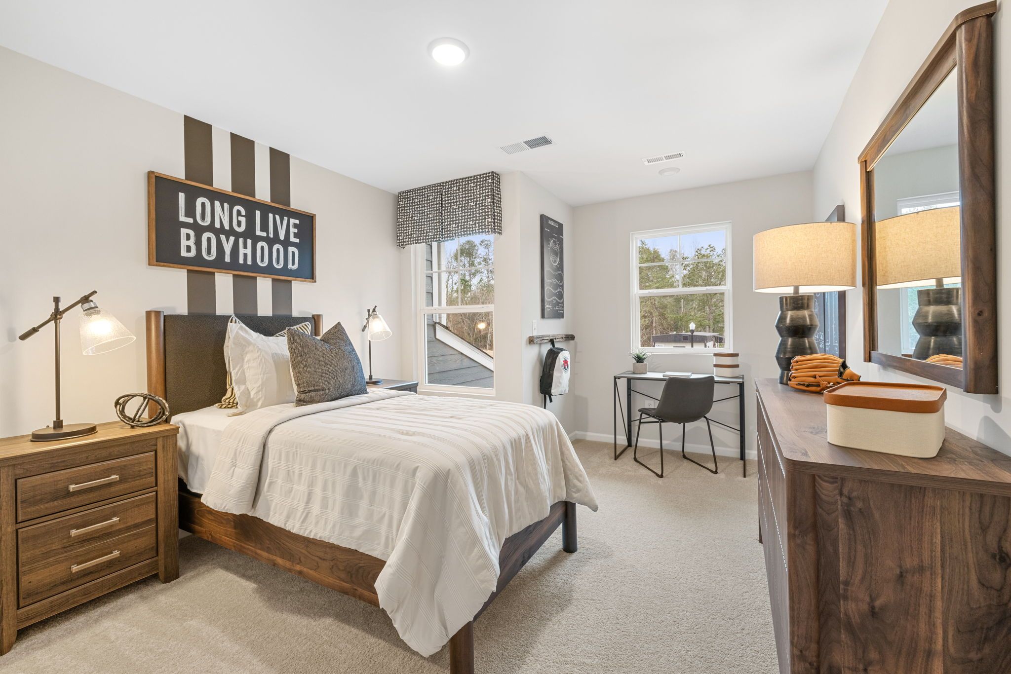 Boy's bedroom with "Long Live Boyhood" sign, wooden bed, desk, mirror at Lake Shore in Winder GA by Davidson Homes
