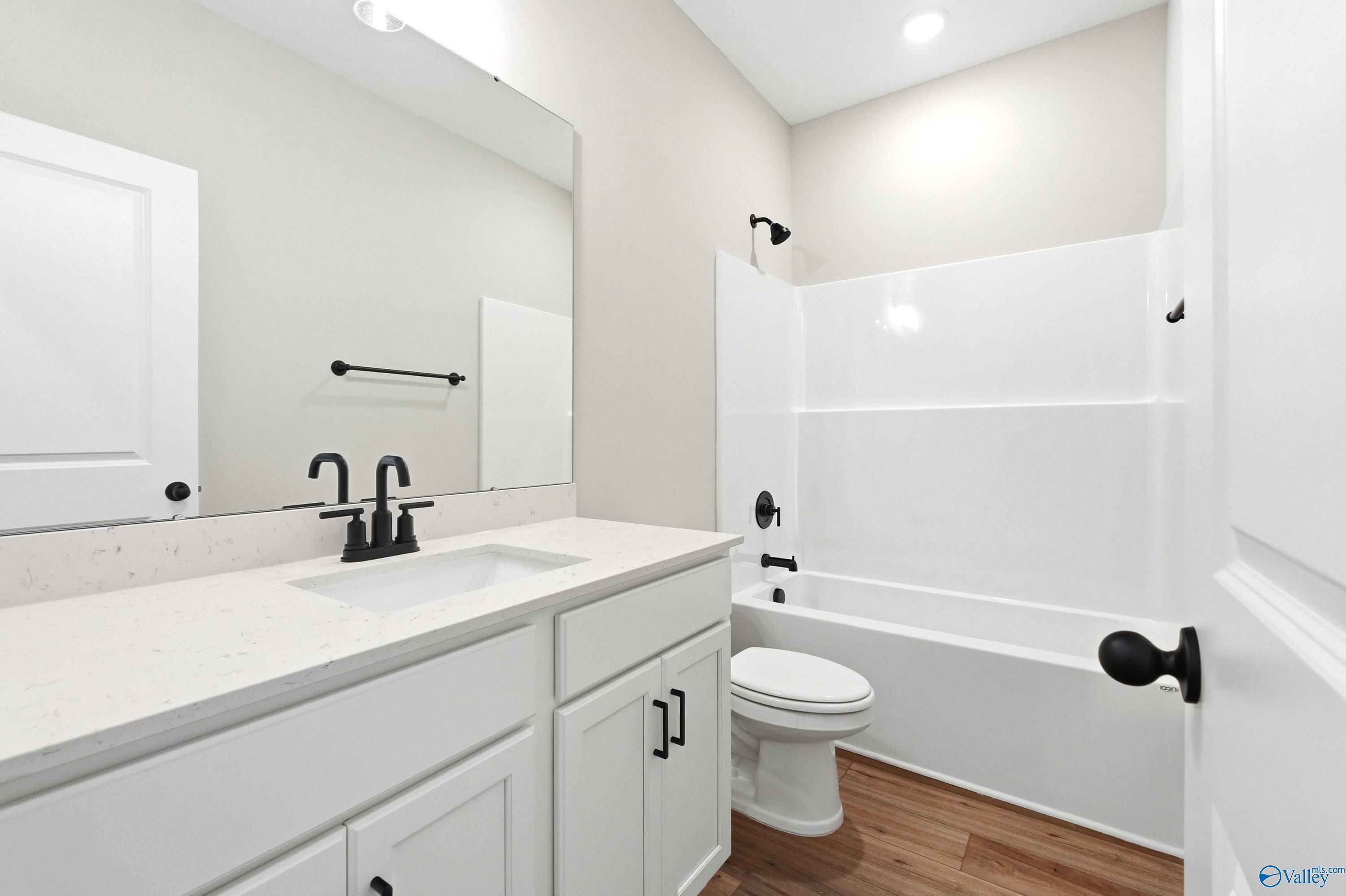 Modern bathroom with white vanity, quartz countertop, and black fixtures in The Daphne D floor plan, Creekside, Harvest AL.